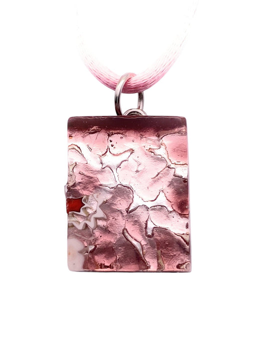 The Murano Passion Murano Glass Pendant on Silver Leaf (MGPP22) is a dainty 2cm x 1.5cm rectangular pink pendant with a textured, crackled surface and red and white accents, suspended from a light pink ribbon necklace.