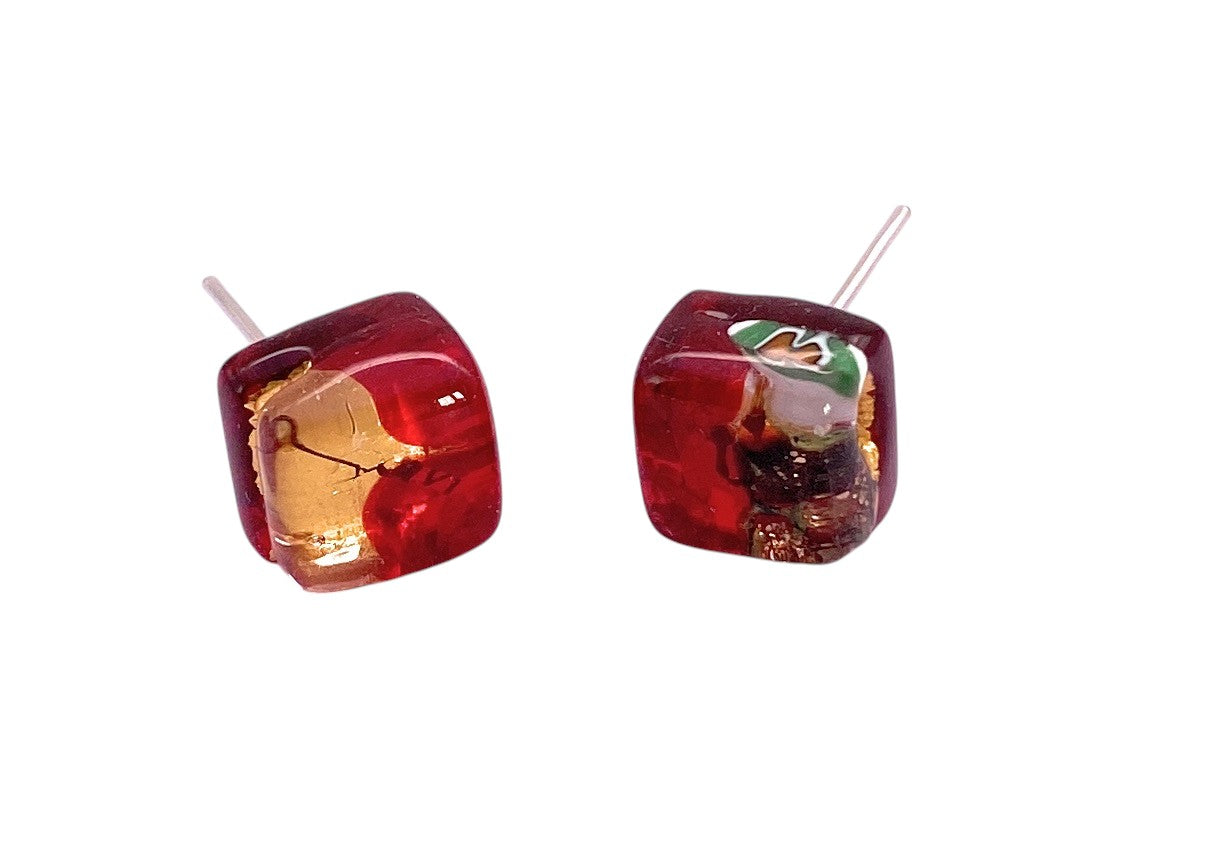 Murano Passion’s Murano Glass Earrings (MGE9) feature dainty 8mm red and gold studs with abstract yellow and green patterns, crafted from translucent glass, each with a visible metal post for fastening.