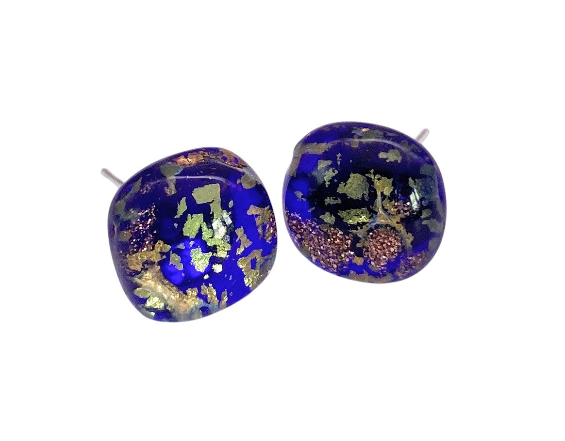 Murano Passion's Murano Glass Earrings (MGE16) feature a deep blue base with gold and green flakes, showcasing handmade artistry. These rounded square earrings (1cm diameter) are displayed on a white background.