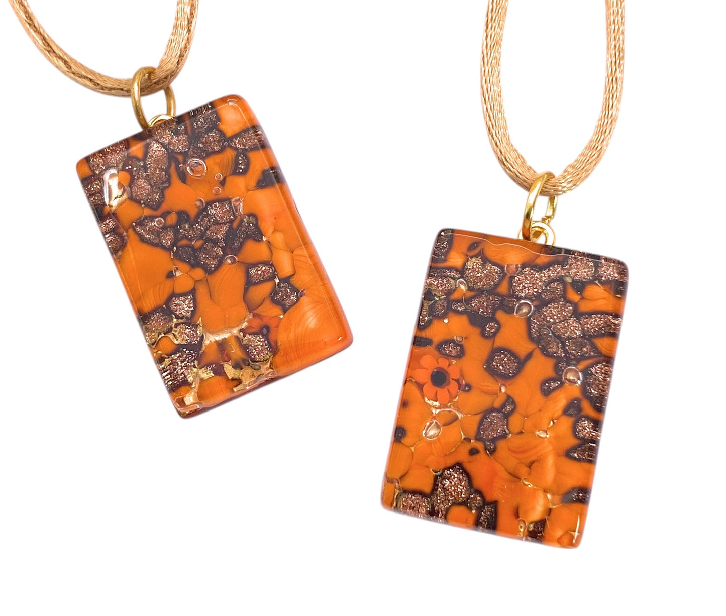 The Murano Passion Murano Glass Pendant with Glitter on Gold Leaf (3cm x 2cm, MGPC7) features orange and black resin with gold flakes on gold-colored chains, displayed on white and includes a Certificate of Authenticity.