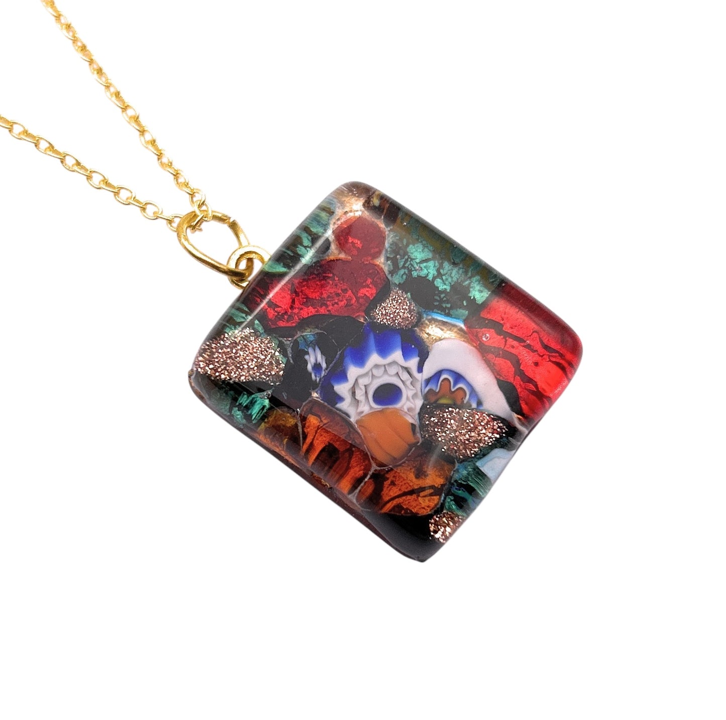 The "WEBSITE EXCLUSIVE - Murano Glass Pendant" by Murano Passion features a vibrant Millefiori mosaic design in red, blue, green, and orange with an eye-like motif on a gold leaf background (2.3cm x 2cm). It comes with a Certificate of Authenticity for its artisanal craftsmanship.
