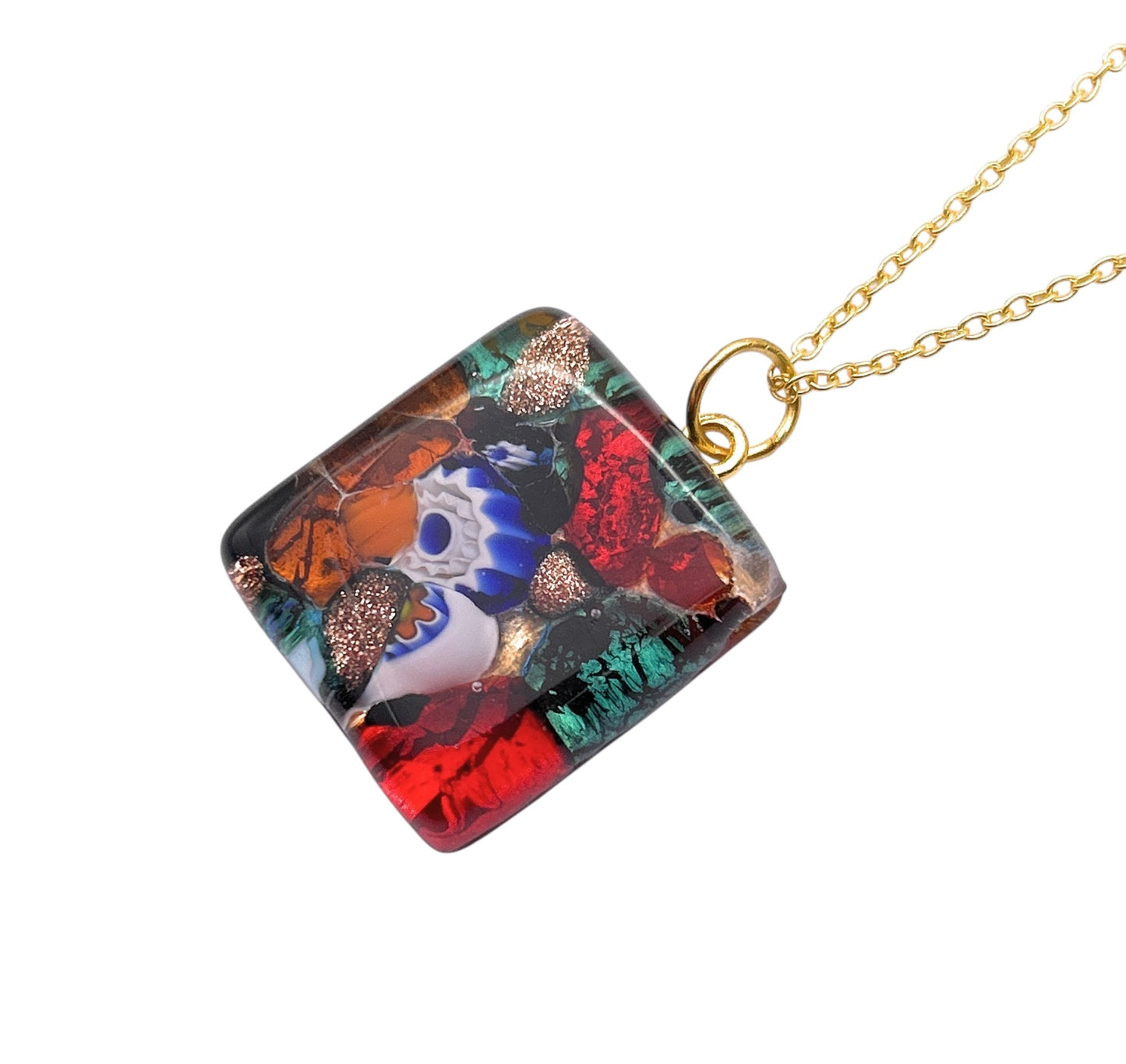 The WEBSITE EXCLUSIVE Murano Glass Pendant by Murano Passion features a 2.3cm x 2cm square design crafted with Millefiori on Gold Leaf, showcasing vibrant red, green, and blue colors in an eye-like pattern. It is handmade and hangs elegantly from a gold chain, including a Certificate of Authenticity.