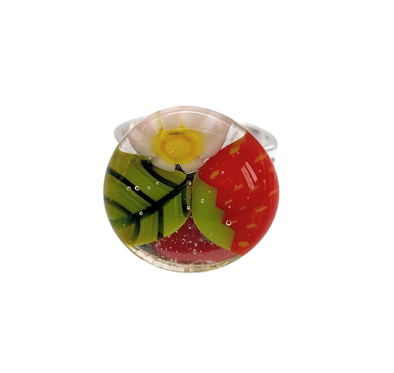 The "Calon Glass" Strawberry Ring, also known as the Flower Ring or Millefiori Ring (CGR7), showcases a spherical design made from handmade glass. It features a vibrant center resembling a yellow and white flower, adorned with green leaf patterns and red accents inspired by strawberries. This exquisite piece beautifully captures light as bubbles dance within its Millefiori craftsmanship.