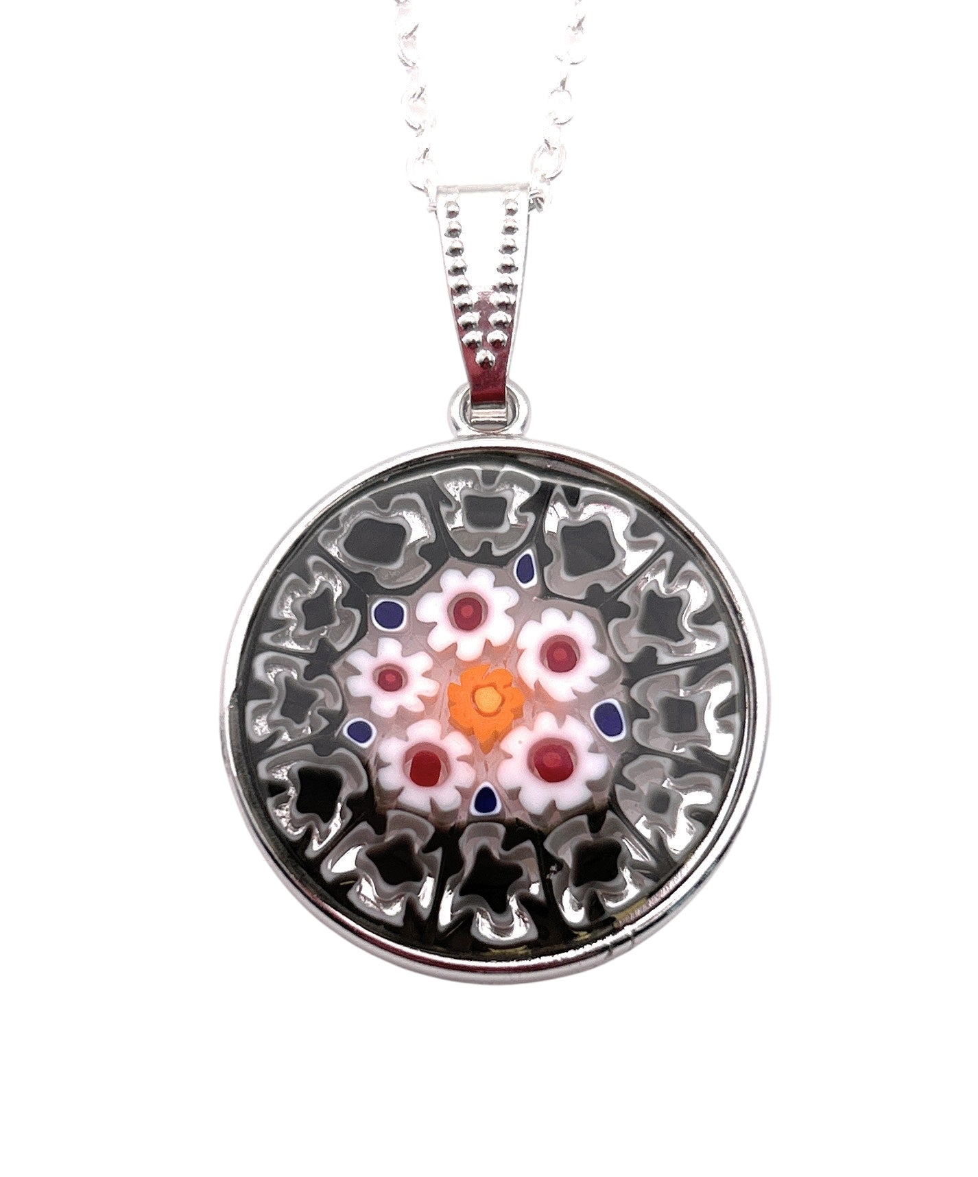 The Murano Passion Murano Glass Pendant, made with 2.4cm Millefiori Flowers, features intricate floral designs in pink, white, and orange with a silver outline. It hangs from a delicate chain and includes a Certificate of Authenticity.
.
