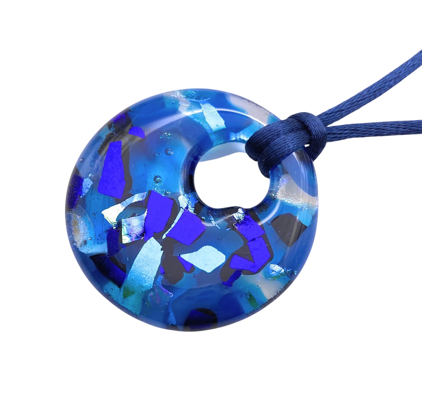 The Calon Glass Handmade Dichroic Pendant (CGP33) features a round, blue glass design with kiln-fused multicolored fragments on a blue cord.