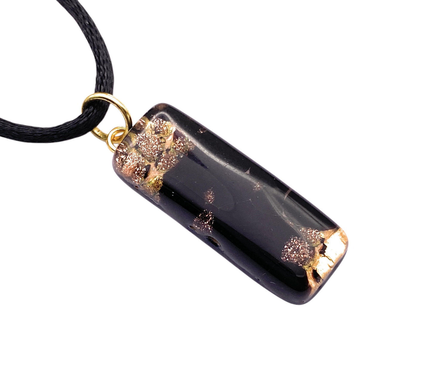 The Murano Passion pendant (MGPL5) features a 3cm x 1cm black rectangle with gold leaf flecks, reminiscent of Murano glass jewellery. Attached to a black cord necklace with a gold loop, its glossy finish adds sparkle to this stunning piece.