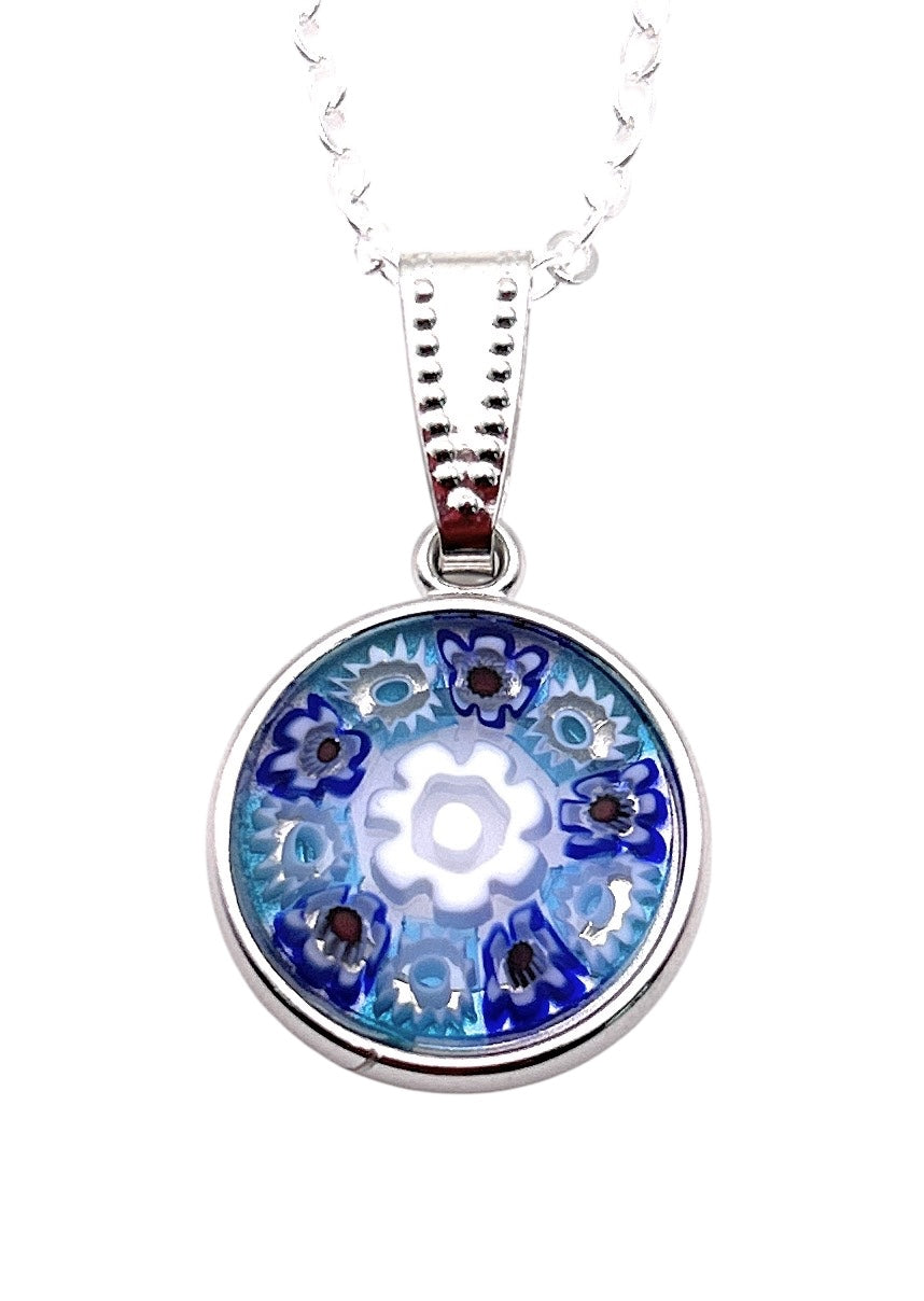 The Murano Passion pendant is a 1.5cm round silver piece crafted with blue and white Millefiori flowers in Murano glass, elegantly showcased on a delicate silver chain.