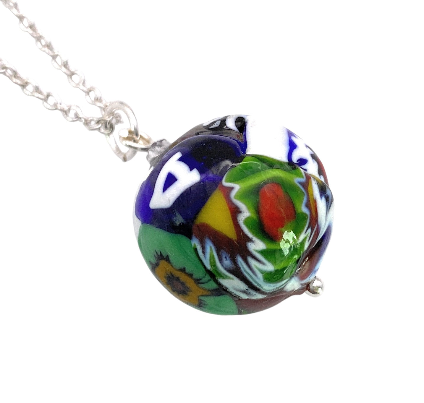 This Murano Glass Multi Coloured Millefiori Ball Pendant (MGB2) by Murano Passion, part of our Murano Glass Jewellery collection, features a stunning display of intricate patterns in vibrant blue, green, red, and yellow. It gracefully suspends from a silver chain and includes a Certificate of Authenticity.