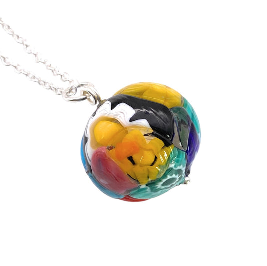 Introducing the Murano Passion Murano Glass Multi Coloured Millefiori Ball Pendant (MGB3), featuring a vibrant spherical pendant on a silver chain. This artistic piece showcases abstract swirls in yellow, red, blue, green, black, and white.