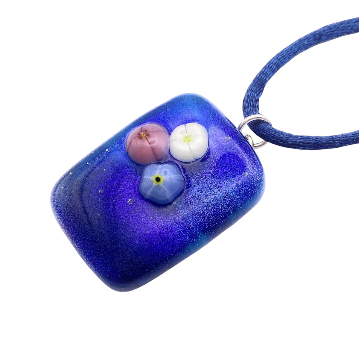 Handmade Dichroic Glass Pendant, Shiny Blue Dichroic Glass with Millefiori Flowers (CGP21) featuring a rectangular blue dichroic glass pendant with three small floral accents on a blue cord necklace.