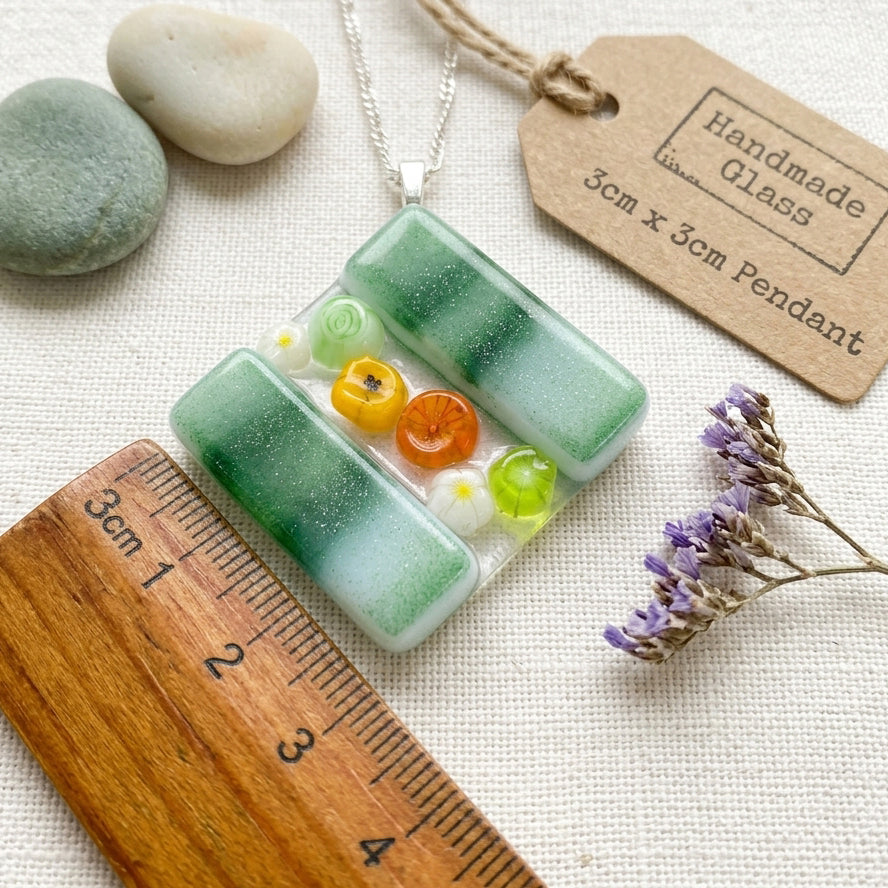 Handmade Glass Pendant made with Millefiori Glass Flowers - 3cm x 3cm (Green) shown next to a ruler for scale.