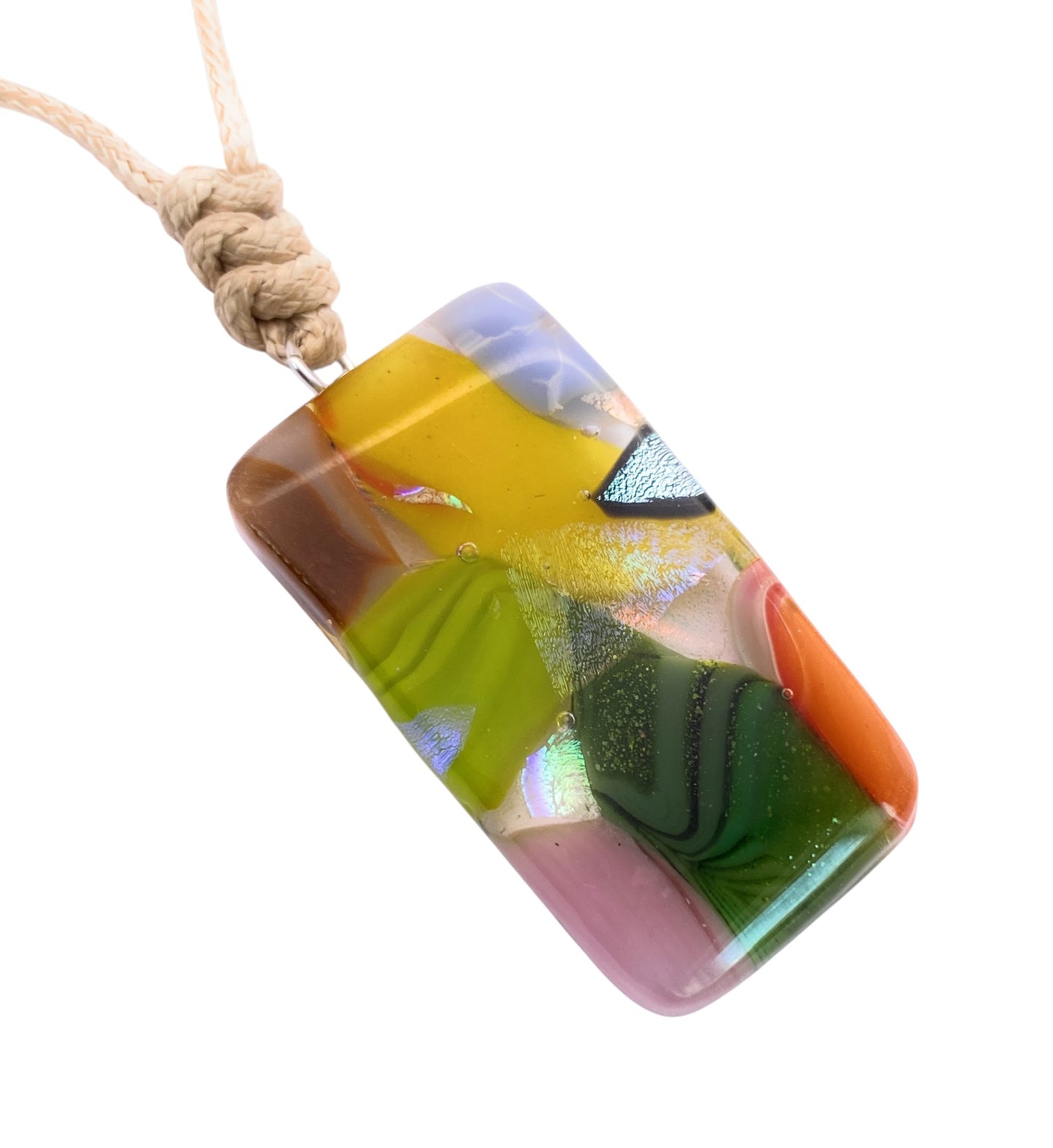 The Handmade Dichroic Glass Mosaic Pendant – Multicolour Fused Glass Statement Necklace (CGP82) by Calon Glass features a rectangular pendant with swirling patterns of green, yellow, pink, orange, and brown glass, suspended from a knotted beige cord.