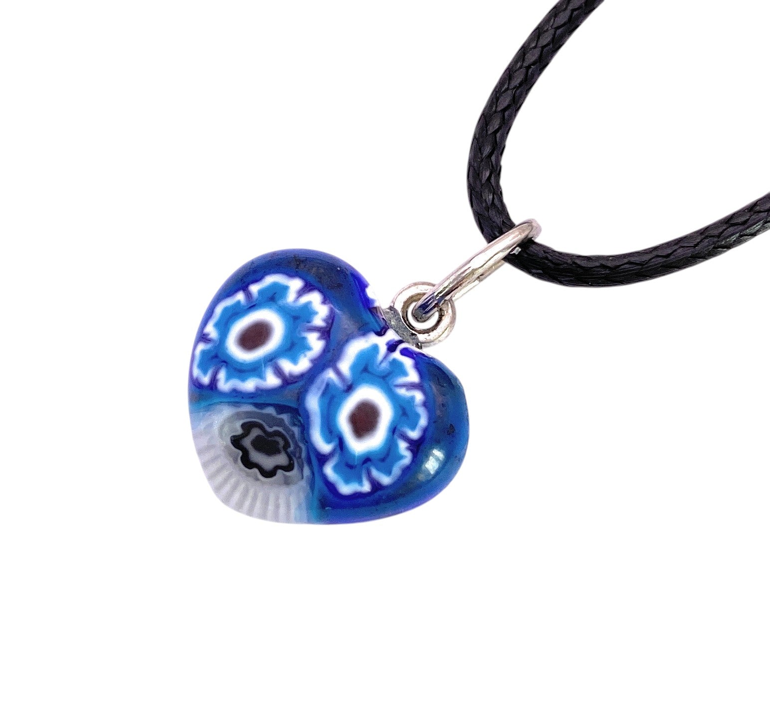 The Murano Passion Murano Heart Pendant (Tiny 1.4cm, MHT6) features a heart-shaped blue glass design adorned with intricate white and black flower patterns, expertly crafted in the tradition of Murano Glass Jewellery from Venice, Italy, and comes attached to a black braided cord necklace.