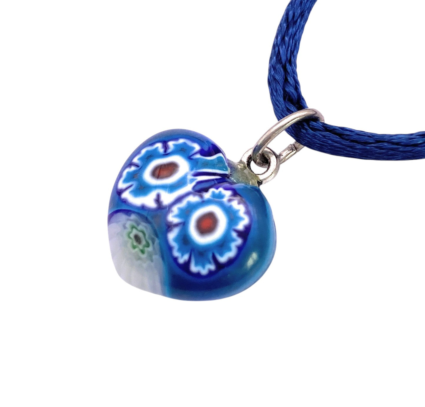 The Murano Passion Murano Glass Pendant, Murano Heart Pendant - Tiny 1.5cm (MHT3) features a blue heart-shaped glass with millefiori floral patterns on a blue braided cord and silver loop.