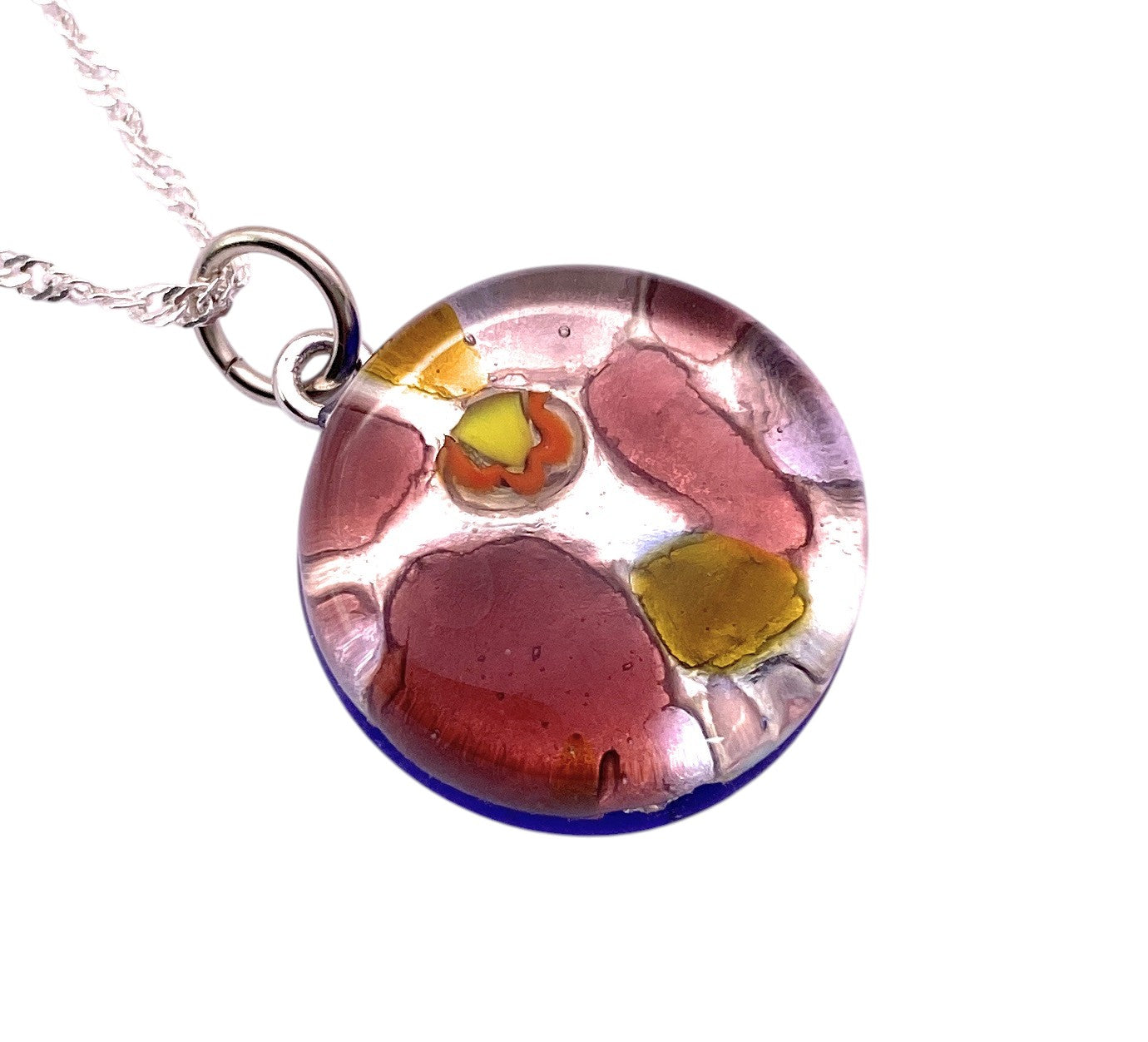 The Murano Passion Murano Glass Round Pendant (MGPV1) features vibrant Millefiori patterns in red, yellow, and orange on clear glass with a blue base—a stunning 2cm Italian jewellery piece inspired by Venice.