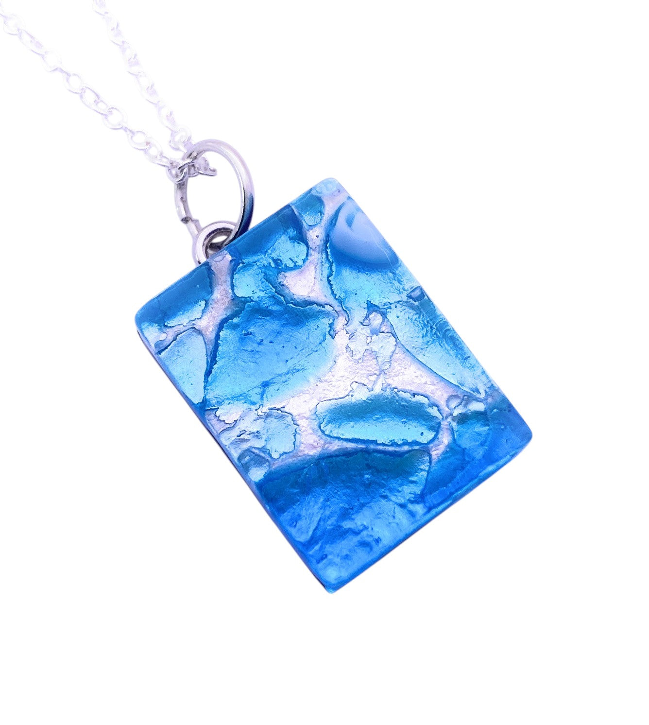 A Murano Passion necklace featuring a dainty 2cm x 1.5cm rectangular sky blue Murano glass pendant with silver leaf, suspended on a silver chain.