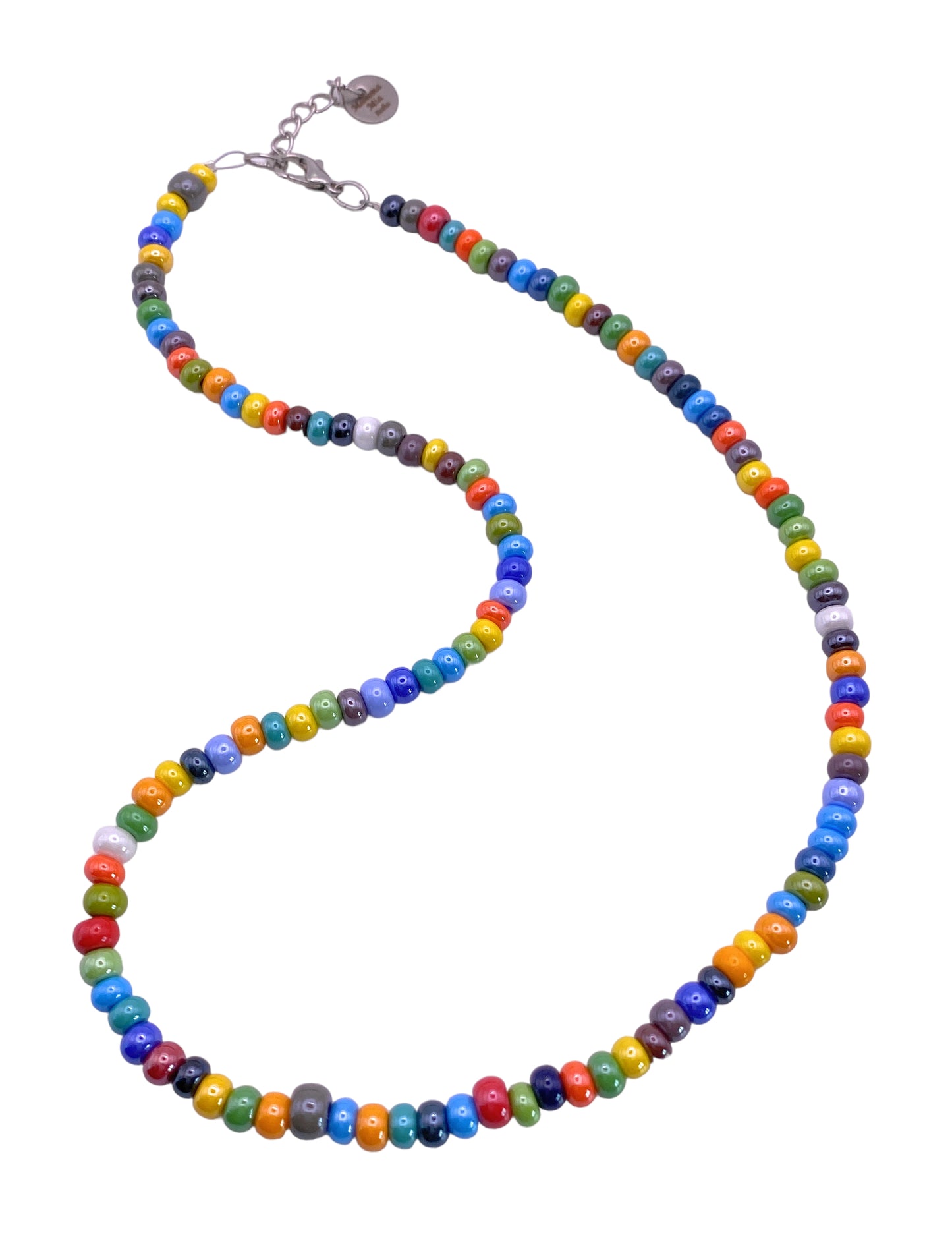 The Murano Passion MGNL1 necklace is a stunning Venetian jewellery piece, showcasing dainty 5mm Murano Glass beads in vibrant rainbow hues of blue, yellow, red, and green. Arranged in a curvy formation on a plain white background, it features a convenient metal clasp with an extender chain.