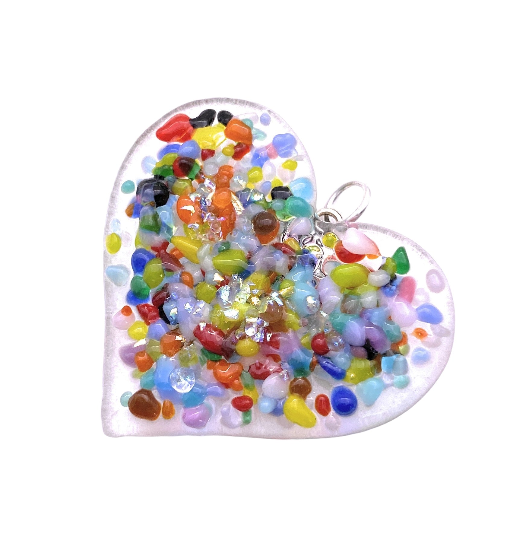 The Calon Glass Handmade Heart Pendant, a 3.5cm x 3.5cm Dichroic Glass Heart Pendant, features a brilliant mosaic of colorful stones in assorted shapes and sizes embedded within clear handmade glass, complete with a silver loop for attachment.