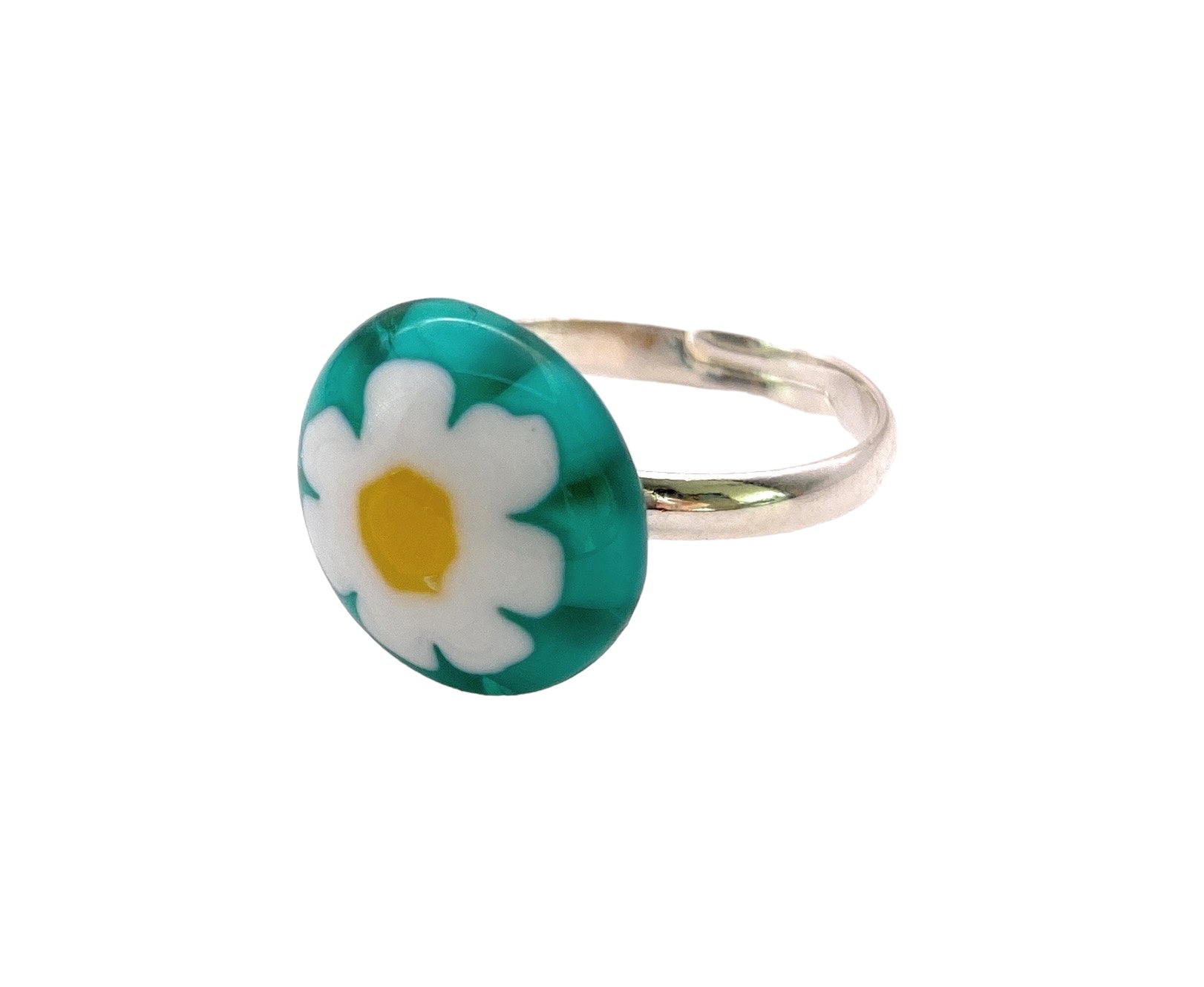 The Calon Glass Handmade Millefiori Glass Ring features a silver band with a dainty 1.4cm round, teal enamel top, showcasing a white daisy with a yellow center in an artful millefiori glass design.