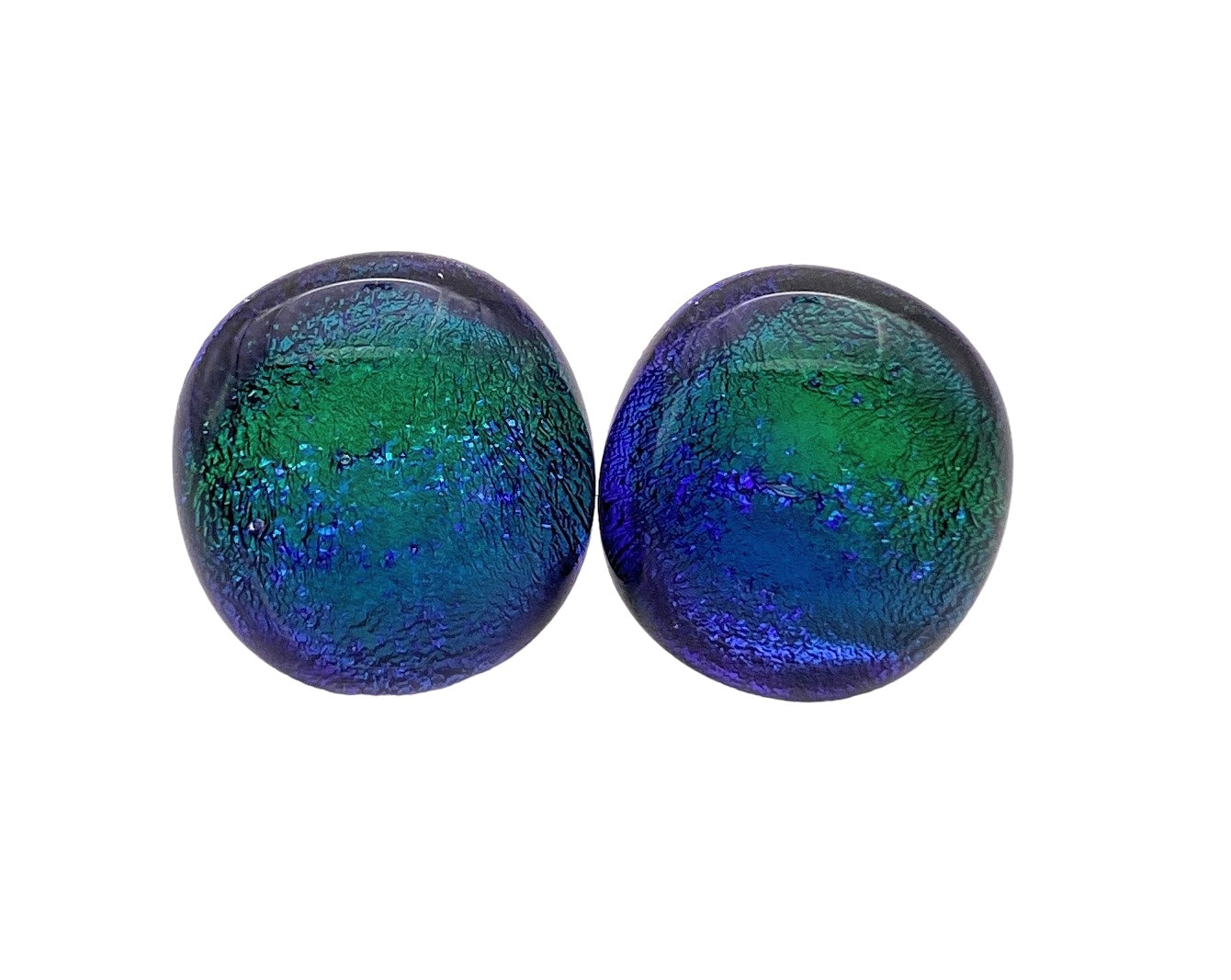 The Calon Glass Handmade Dichroic Glass Earrings feature two round cabochons with iridescent blue and green hues, exhibiting a textured surface and glossy finish. These 1.4cm pieces resemble dichroic glass and are elegantly positioned side by side on a plain white background, ideal for crafting unique jewelry.