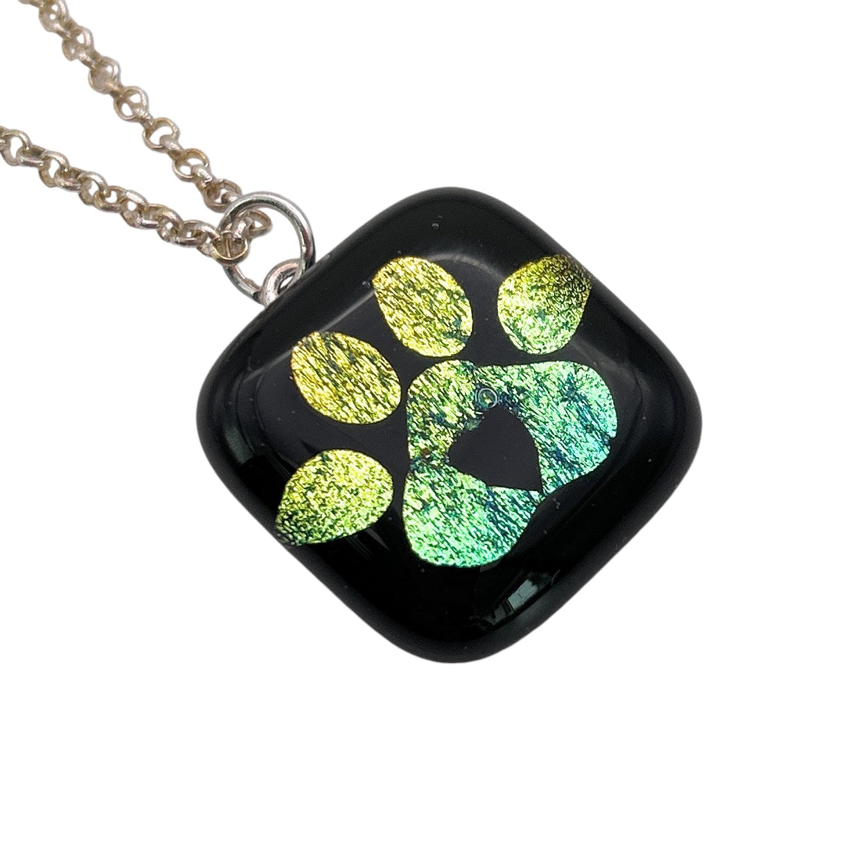 A pendant necklace features a green paw print design with a heart shape on black glass