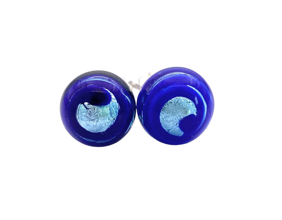 A pair of Murano Passion's Murano Glass Earrings (MGE12) with an 8mm diameter, featuring a reflective surface with a smooth and polished finish, adorned with a shiny silver leaf in the design of crescent moons. These exquisite navy blue studs come with a Certificate of Authenticity.