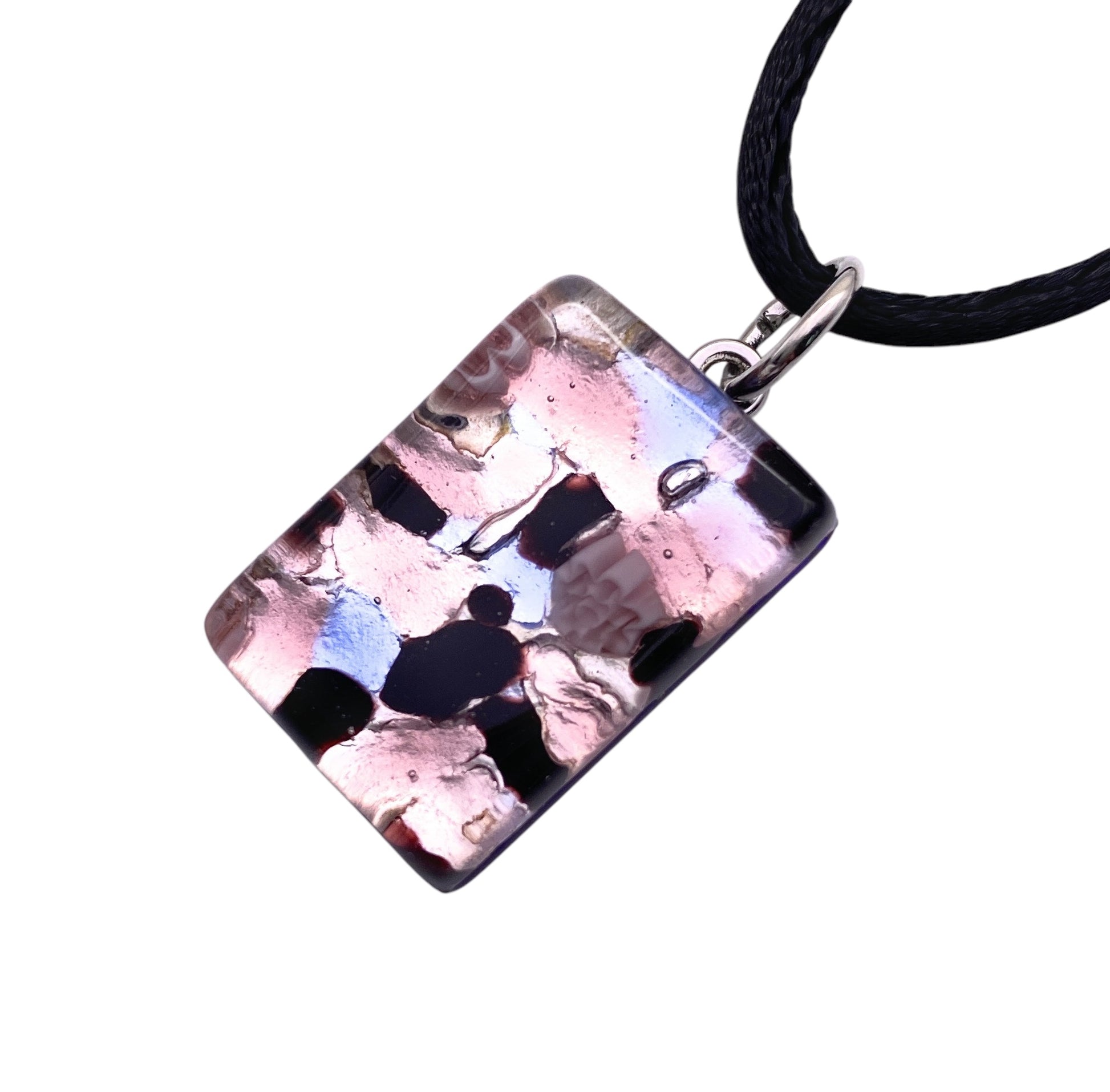 The Murano Passion pendant, model MGPP10, features a dainty 2.5cm x 1.5cm rectangular charm with a mosaic of pink, black, and white patterns on a black cord necklace. This handmade piece includes a Certificate of Authenticity for genuine Murano glass craftsmanship.