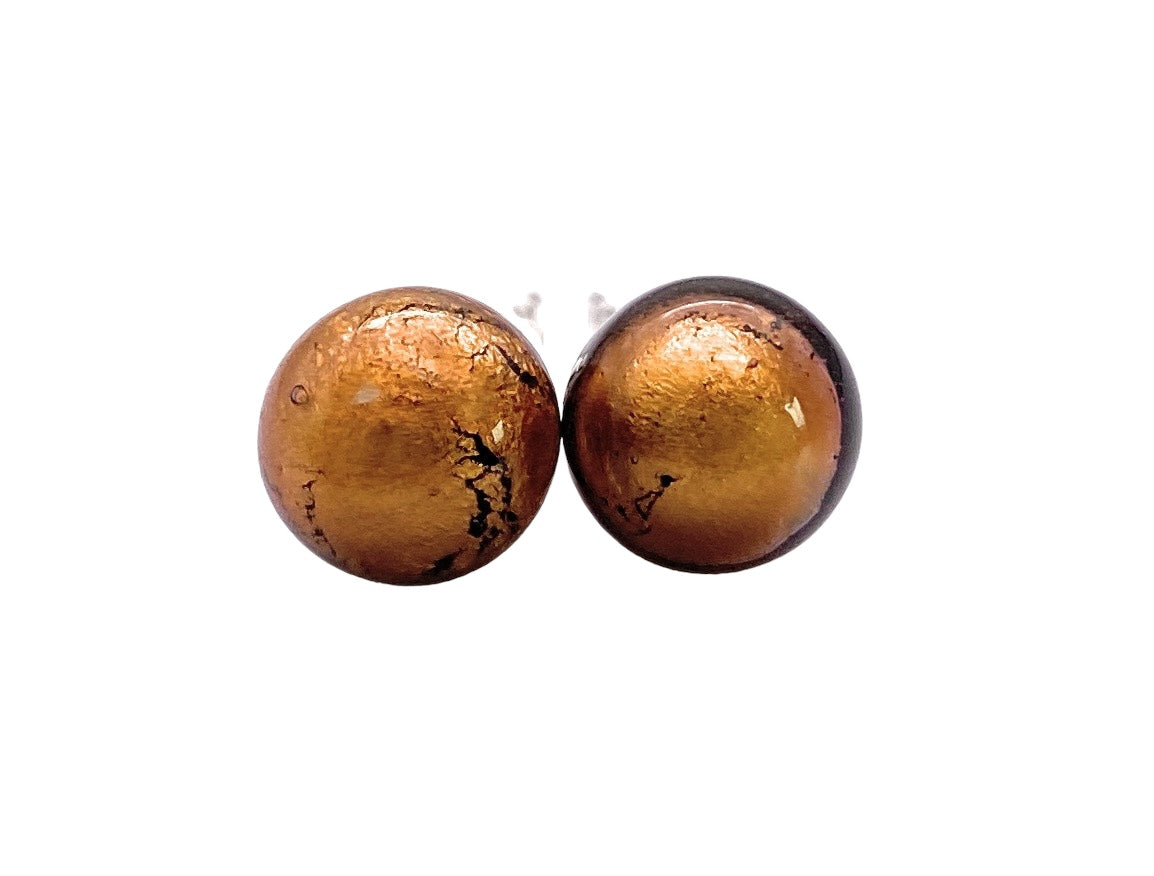 A pair of round, domed Murano Passion earrings with an 8mm diameter and a shiny, metallic bronze finish, featuring a textured surface on silver-plated studs (MGE13), displayed side by side against a white background.