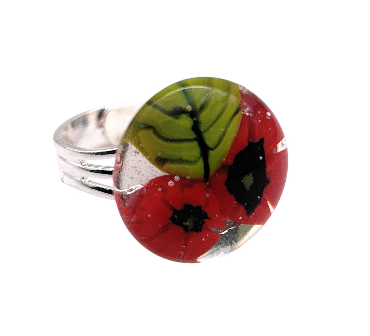 A Calon Glass "Poppy Ring" features a silver band and a round handmade glass top, showcasing Millefiori flowers in red with green leaves.