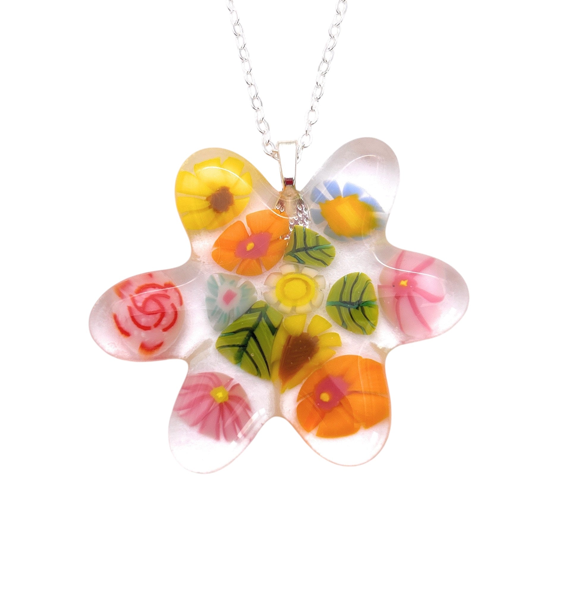 A chunky Millefiori flower pendant, crafted from handmade glass with colorful designs in yellow, pink, orange, and red by Calon Glass (CGP31), hangs gracefully from a silver chain.