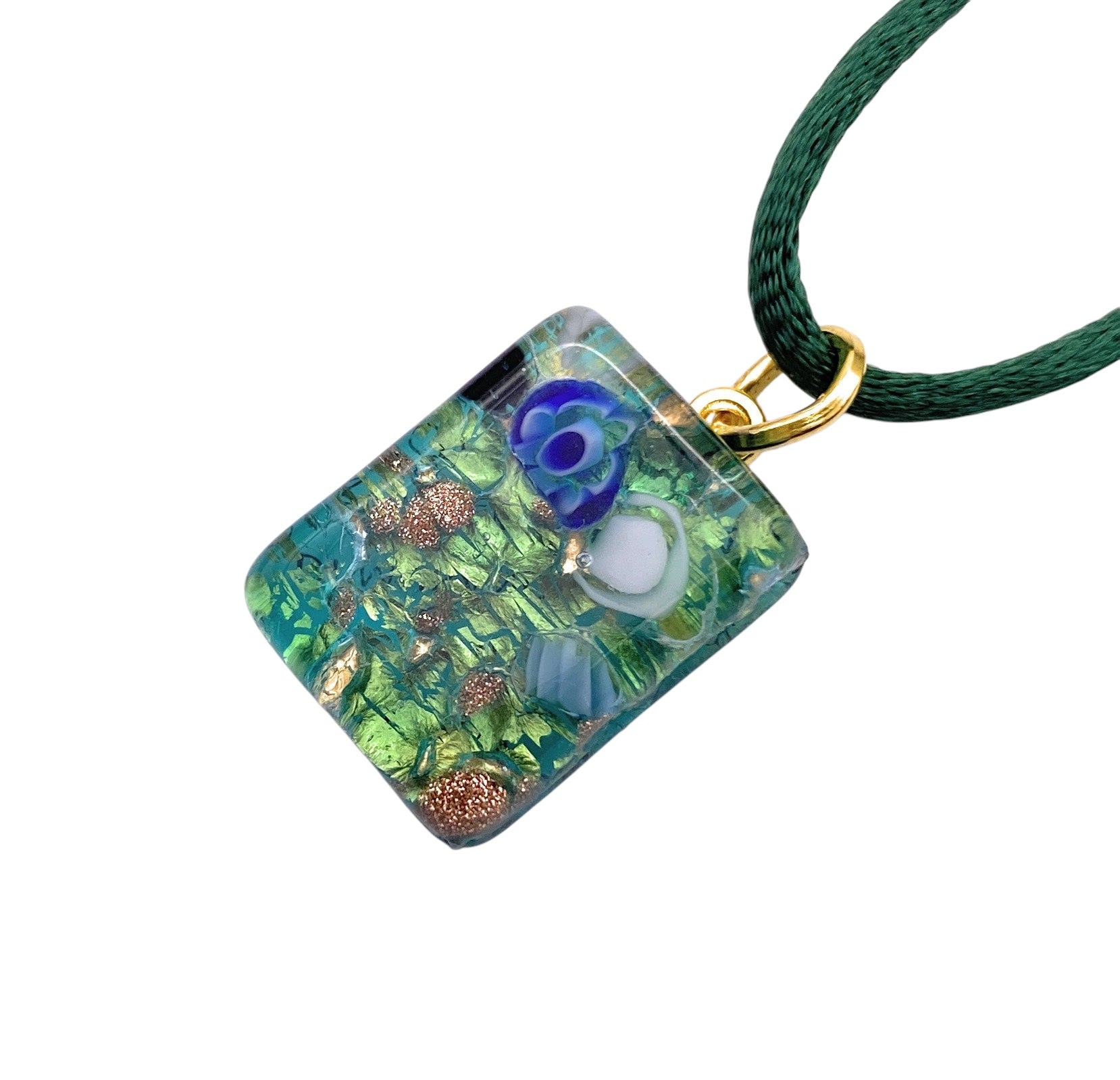 The Murano Passion MGPP34 pendant is a 2cm x 1.5cm masterpiece featuring embedded green and gold floral designs on Murano glass, attached to a dark green cord with a gold loop.