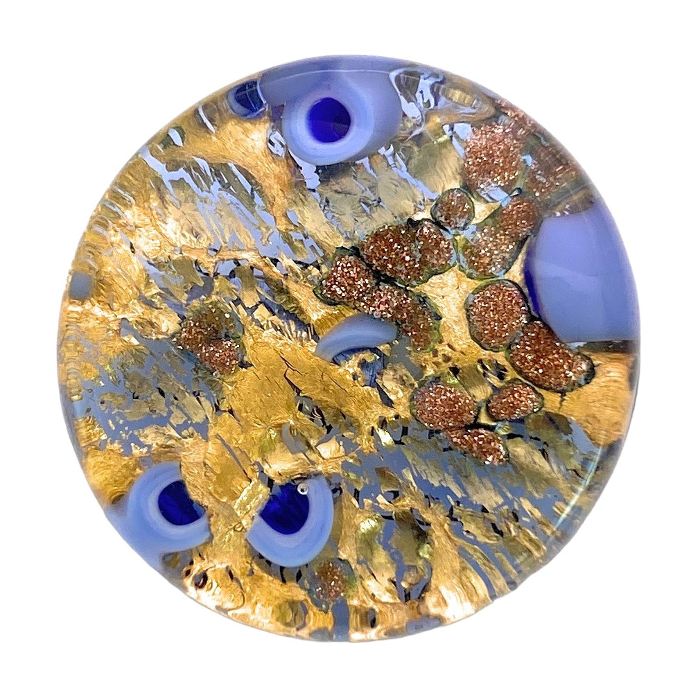 The Murano Glass Brooch with Millefiori on a Gold Leaf Base by Murano Passion captures the essence of classic Venetian artistry, featuring a vibrant blend of gold, blue, and copper tones in a marbled pattern. Its intricate design displays swirling abstract shapes and shimmering metallic accents on its glossy surface.