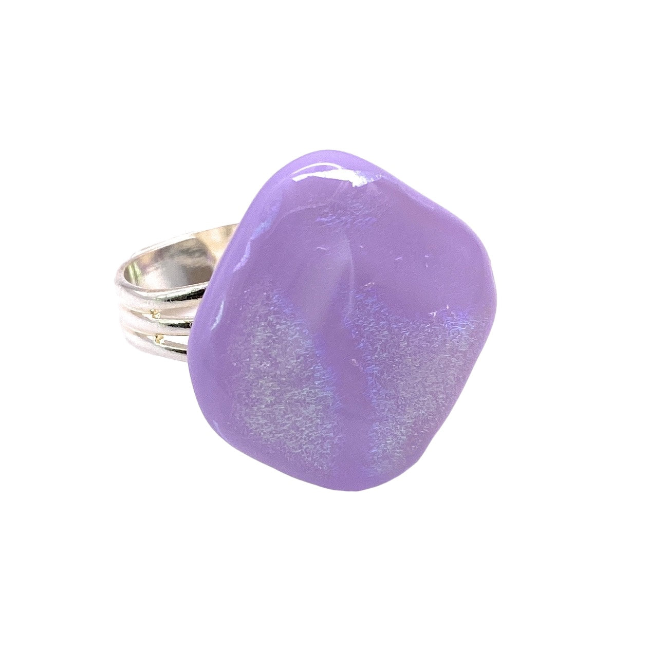 A silver ring from Calon Glass, showcasing a large lilac stone with a shimmering surface and a slightly irregular shape, highlights the elegance of handmade glass jewelry.