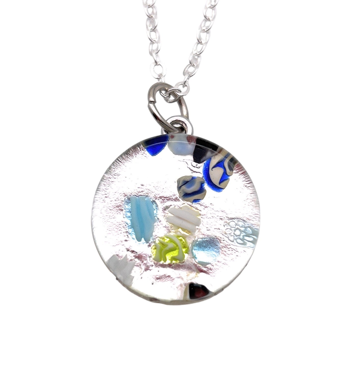 The Murano Passion Murano Glass Round Pendant made with Millefiori - 2cm (MGPV21) presents a refined round glass design suspended on a silver chain, featuring vivid abstract patterns in blue, green, and silver hues, and includes a Certificate of Authenticity.