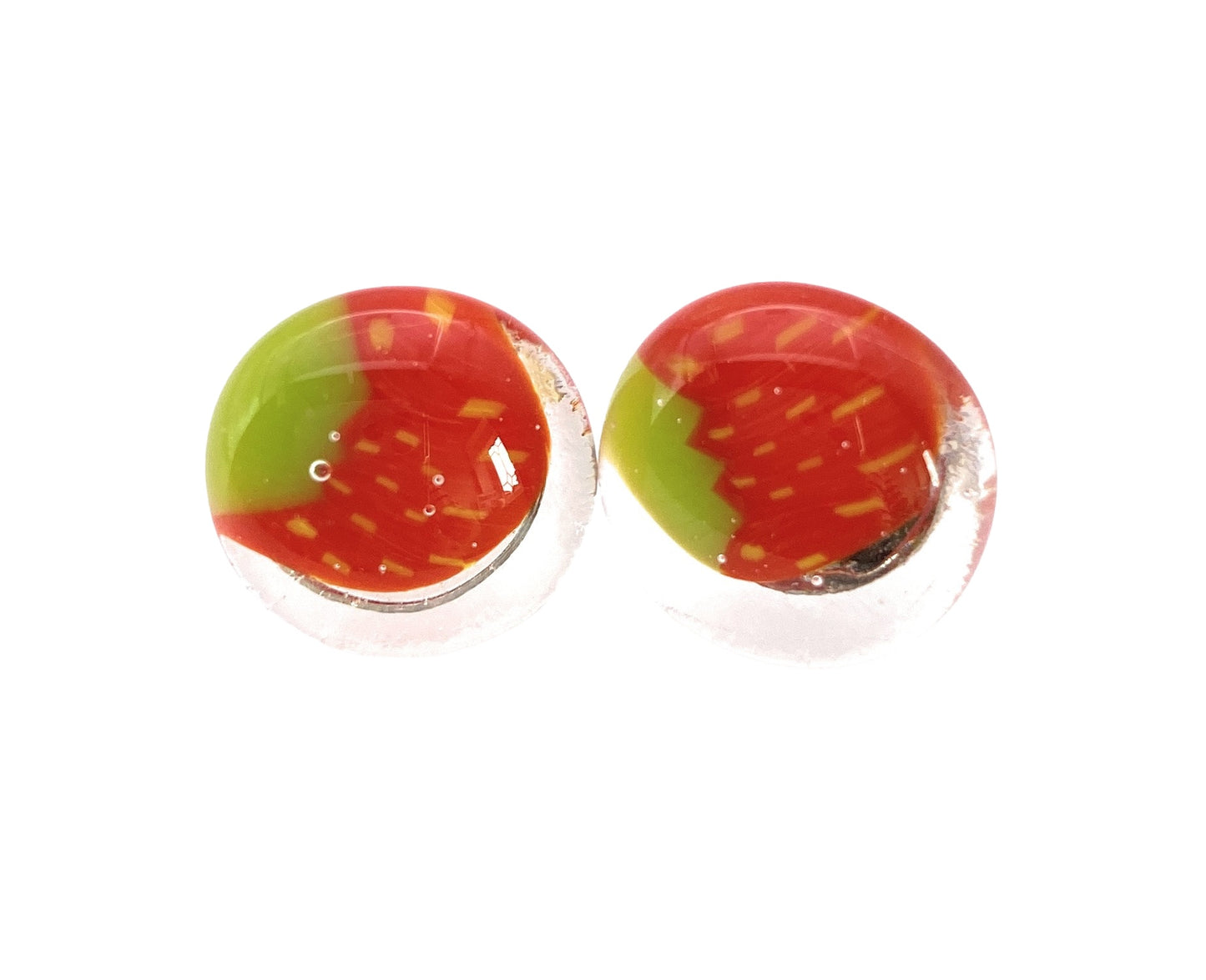 The Handmade Glass Earrings from Calon Glass, styled with a strawberry motif featuring vibrant red and green segments, are crafted using Millefiori glass and finished with a sleek, shiny surface. Measuring 1.5cm in size, these earrings offer a unique and colorful design.