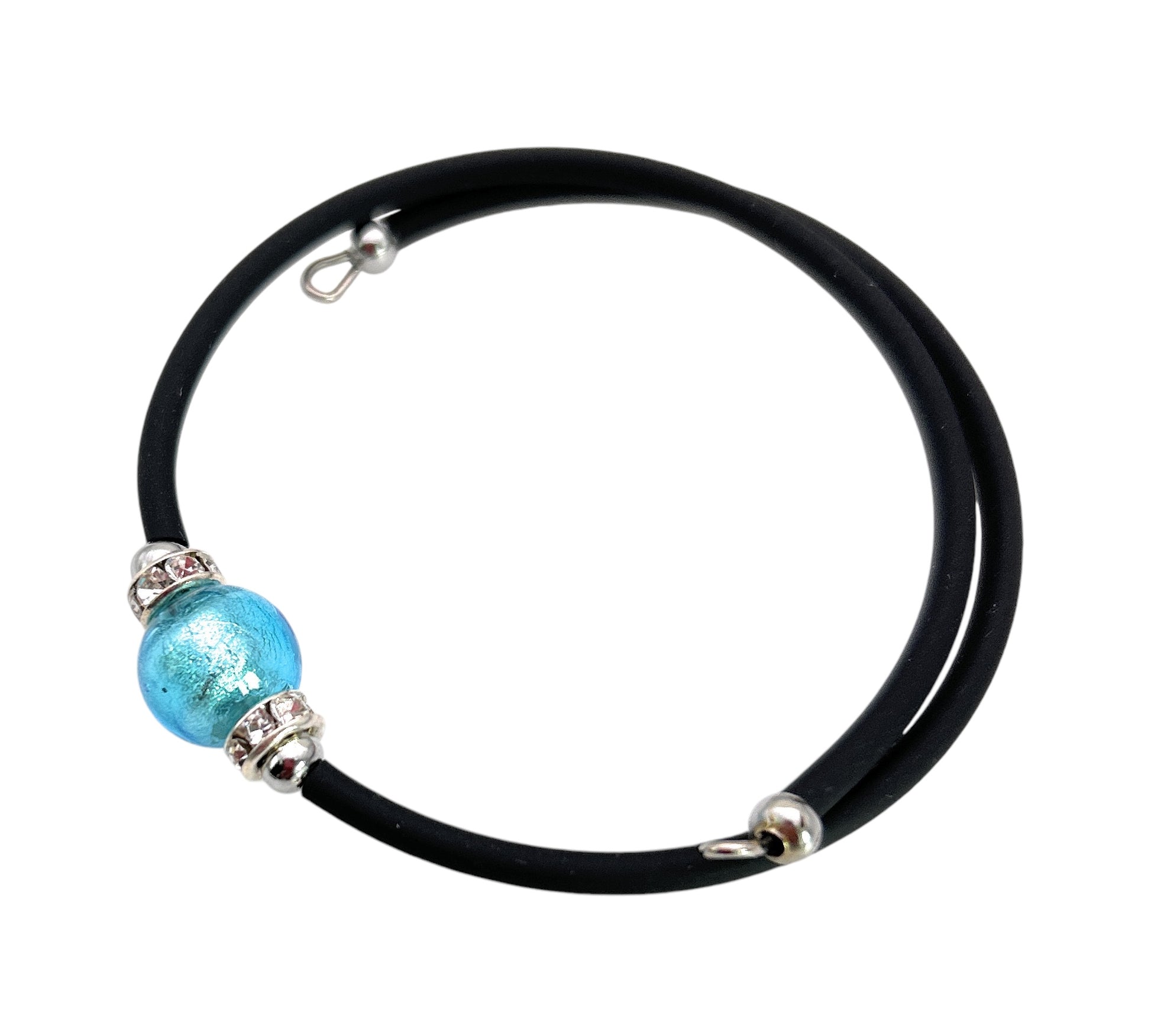 The Murano Passion bracelet, named the Murano Glass Bead Bracelet, showcases a striking 1cm blue Murano Glass bead at its center on a black rubber cord. This piece is accentuated by silver accents and fastened with a hook clasp, perfectly capturing the elegance of handmade Murano Glass Jewellery.