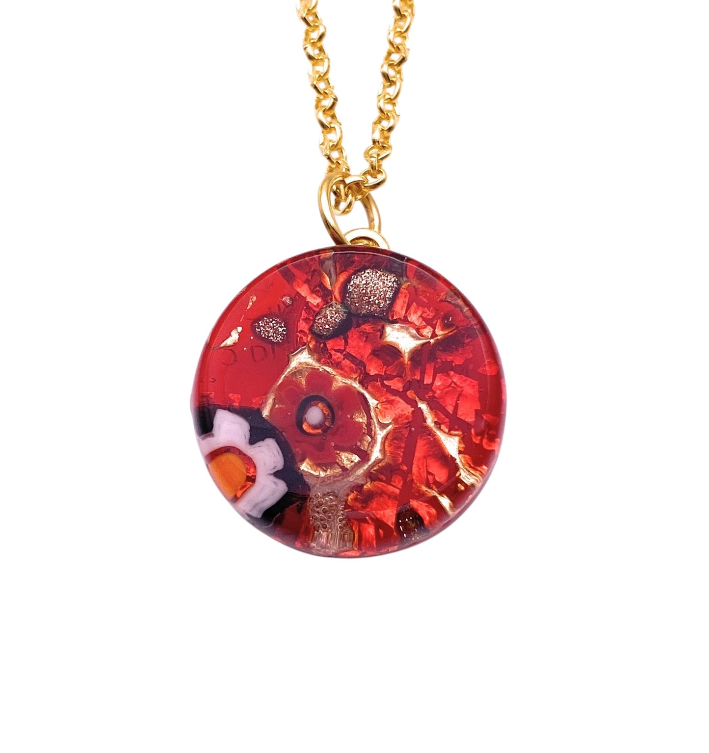 The Murano Passion pendant (MGPV22) is a vibrant red, round Murano glass piece with intricate white and orange Millefiori floral designs. It hangs from a golden chain, features a glossy finish, and comes with authenticity certification for an elegant touch.