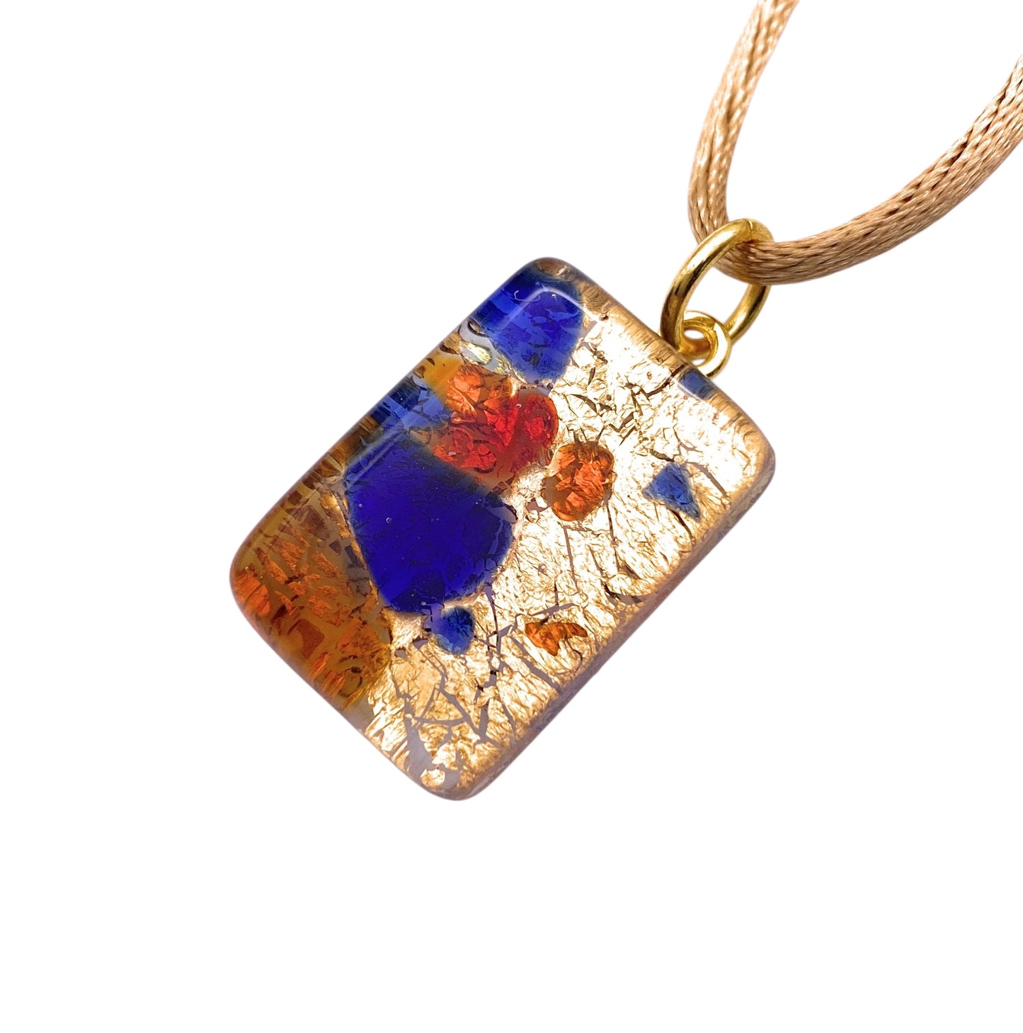 The Murano Passion Millefiori Pendant features abstract red, blue, and gold patterns on a rectangular glass piece (2cm x 1.5cm), elegantly attached to a beige cord. This genuine Murano Glass piece comes with a Certificate of Authenticity for assurance (Product: MGPP5).