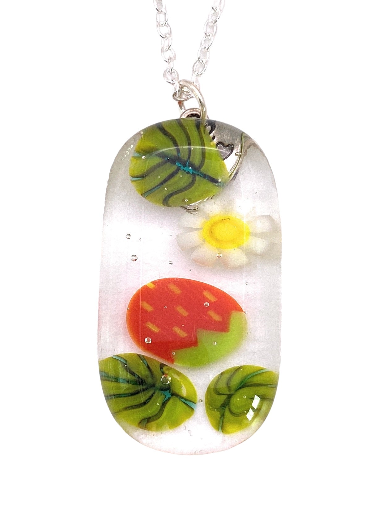 The Calon Glass Handmade Glass Pendant, known as the Strawberry Pendant, features a 3.5cm by 2cm translucent design with an inner flower, red egg, and green striped pattern. It elegantly hangs from a delicate silver chain.