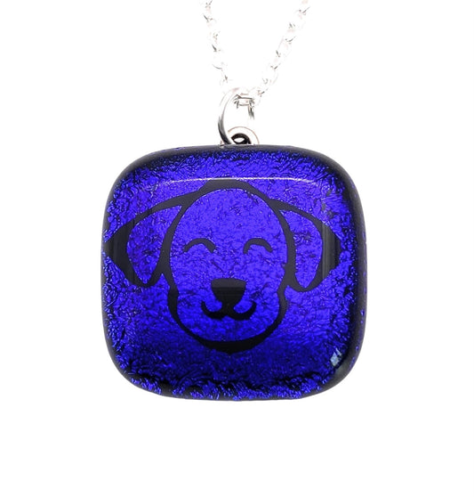 Presenting the Handmade Dichroic Glass Pendant from Calon Glass, featuring a 2cm x 2cm pendant with a blue square design and the etched silhouette of a smiling dog's face, elegantly hanging on a silver chain.