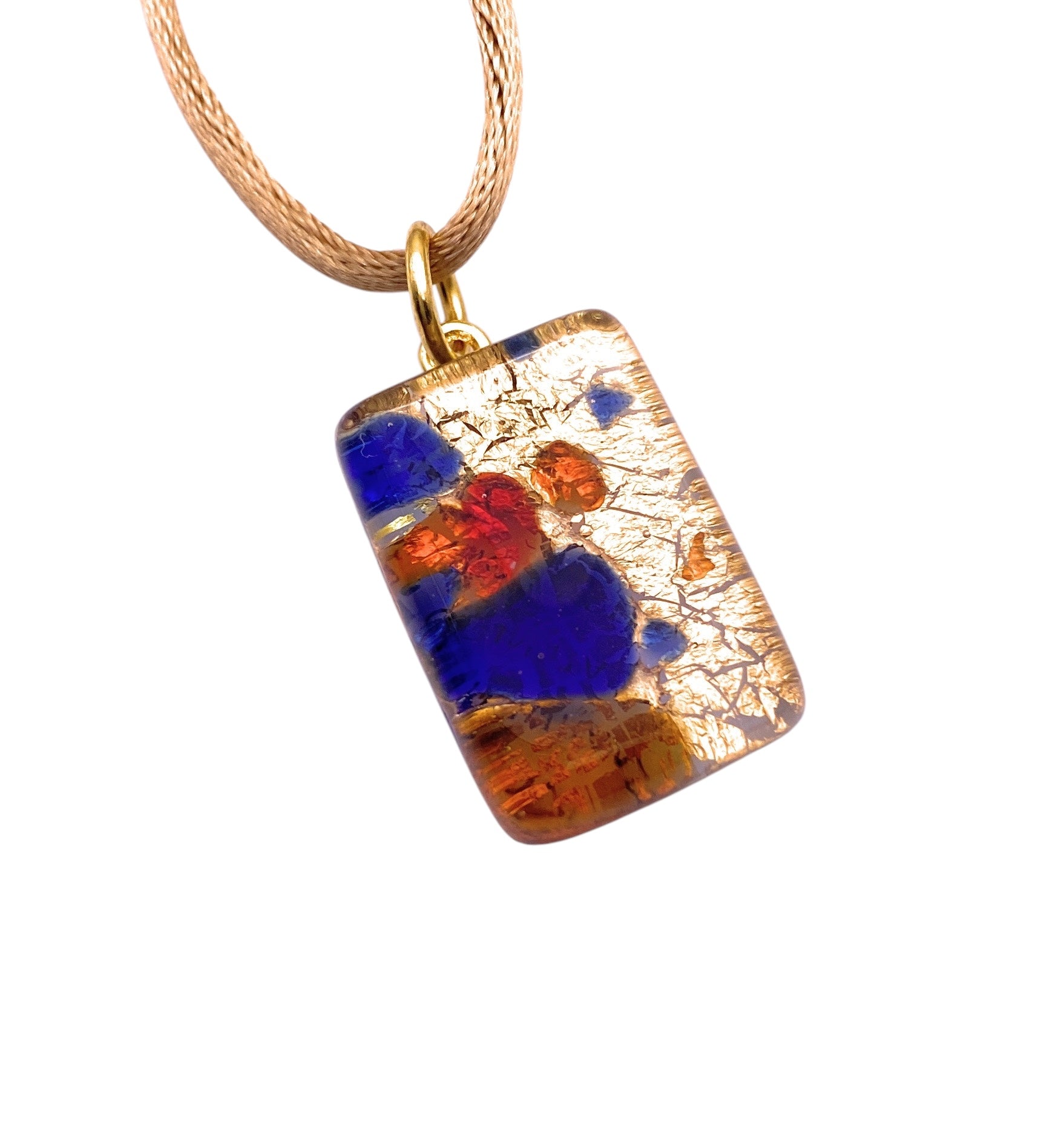 The Murano Passion Pendant, Millefiori on Gold Leaf (2cm x 1.5cm), hangs from a chain featuring an abstract design with blue, red, and orange accents on a textured background. This unique Murano Glass Jewellery includes a Certificate of Authenticity.