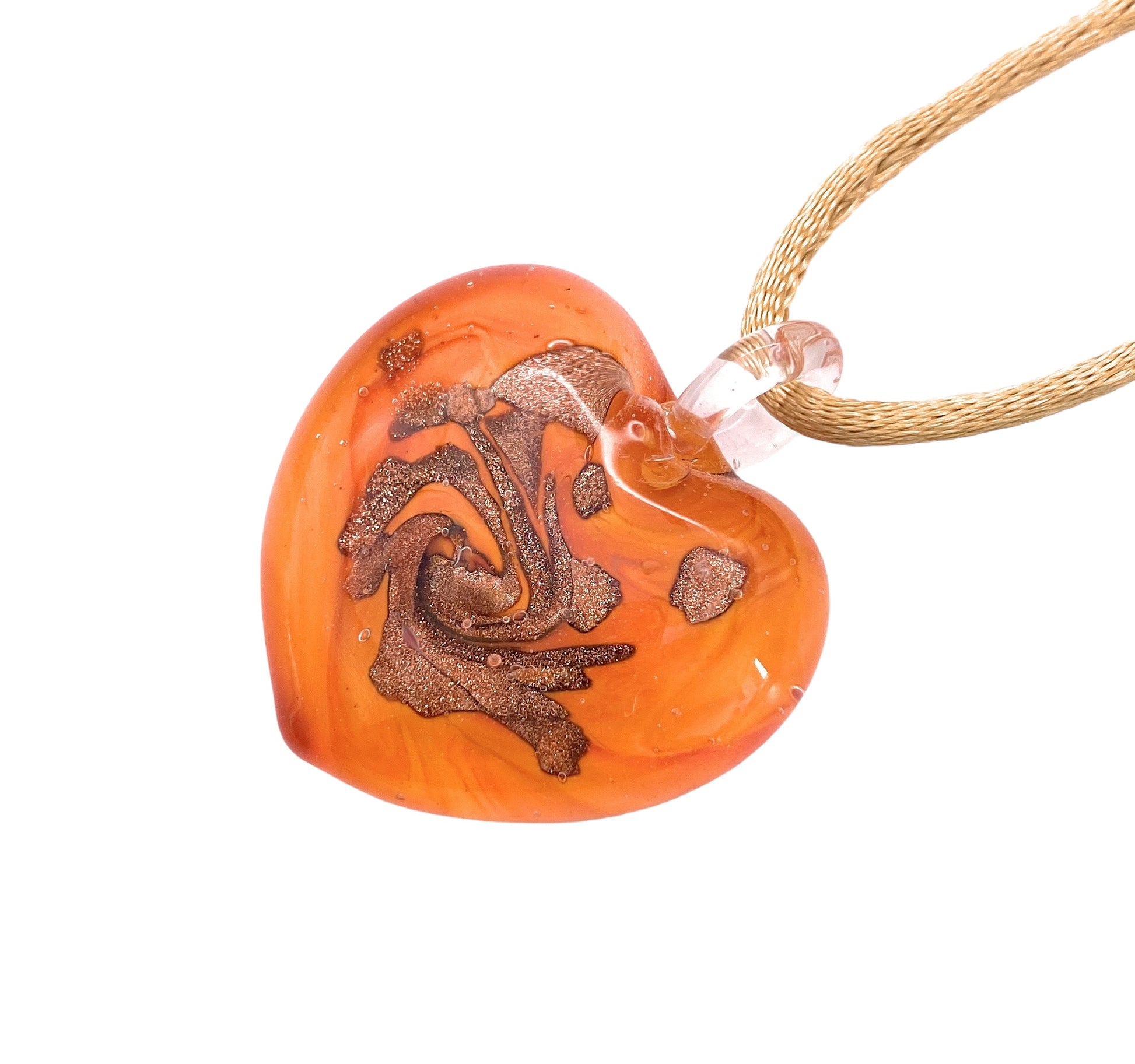 The Murano Passion Murano Glass Heart Pendant, a handmade 3cm masterpiece, showcases a swirling metallic gold design embedded within its heart-shaped amber-orange glass. It is elegantly paired with a transparent loop for hanging on a golden twisted rope necklace and includes a Certificate of Authenticity to guarantee genuine Murano Glass Jewellery.