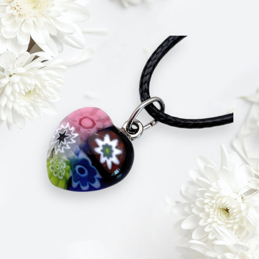 The Murano Passion Murano Heart Pendant, a delicate 1.3cm piece adorned with colorful floral patterns, rests gracefully among white chrysanthemums on a light background, radiating elegance and charm.