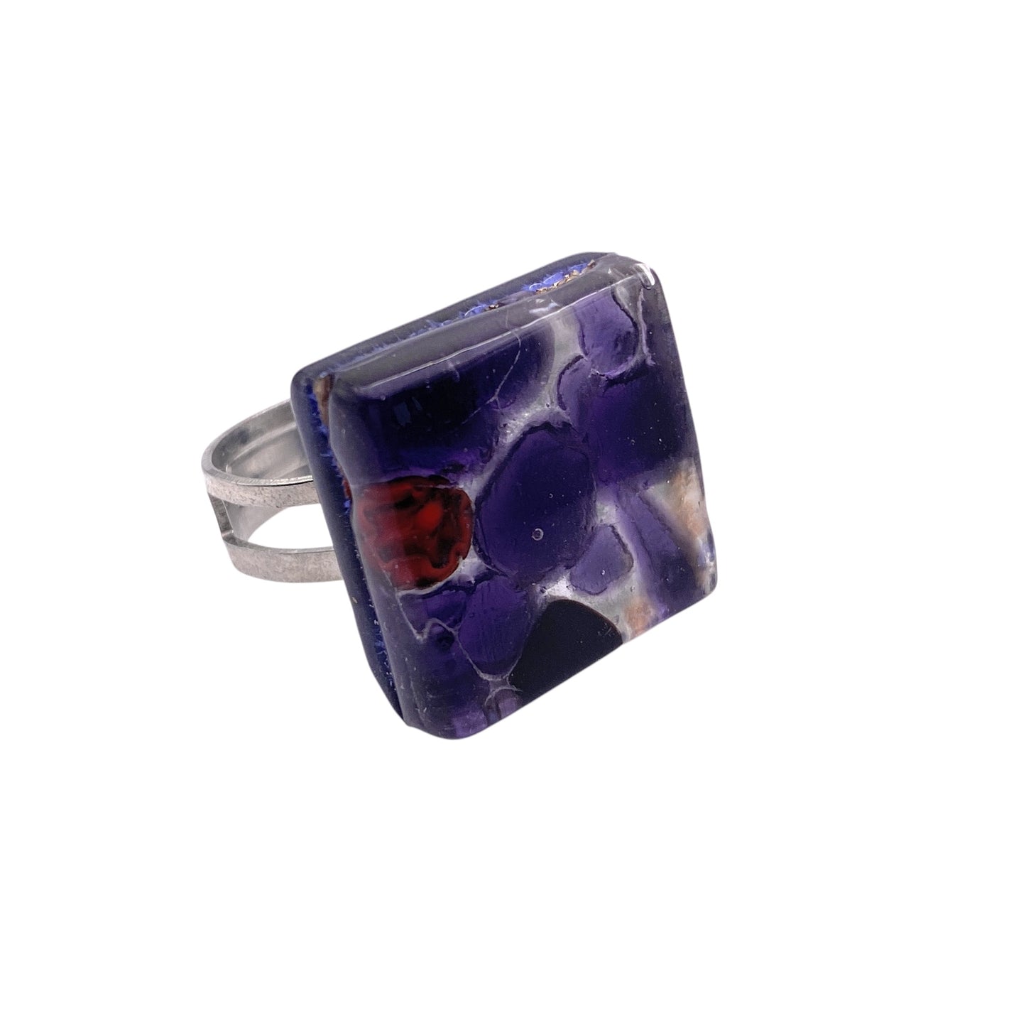 The Murano Passion ring, crafted from genuine Millefiori glass, displays a vibrant mosaic of purple, blue, and red on a silver band. Handmade in Murano, this 2cm x 2cm piece (MGR1) embodies Venetian artistic heritage.