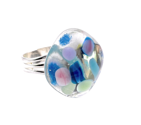 The Calon Glass Handmade Dichroic Glass Ring features a striking 2cm multicolored mosaic glass piece with abstract designs in vibrant blue, pink, and green hues, offering an artistic and modern look. Its adjustable silver-plated band provides a perfect fit for those looking for unique multicolored glass jewelry.