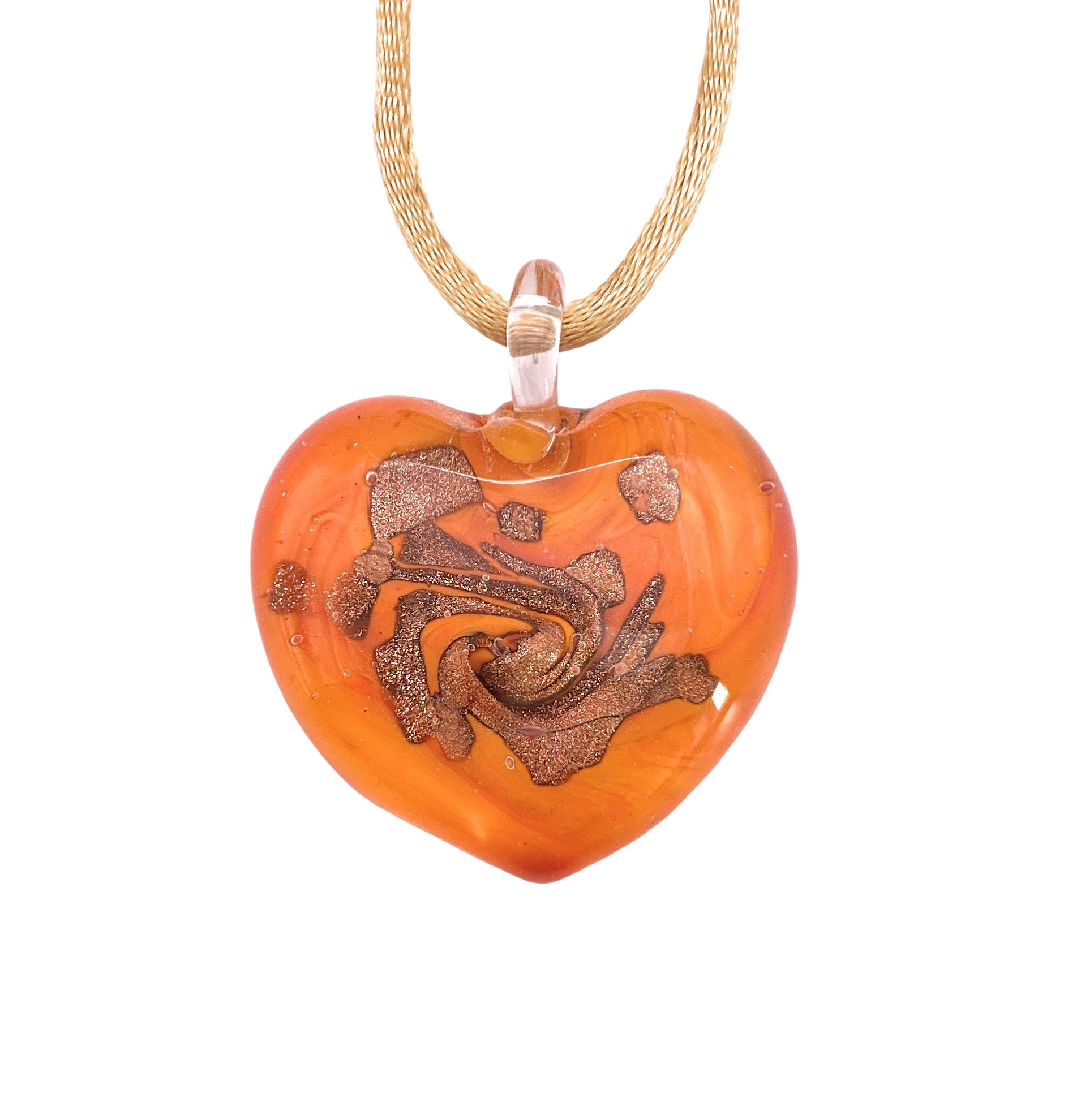 A Murano Passion Heart Pendant, meticulously crafted with vibrant orange glass and swirling brown patterns, elegantly suspends from a golden chain. This glossy 3cm piece exemplifies intricate design elements, showcasing the exceptional artistry that makes Murano Glass Jewellery so cherished.