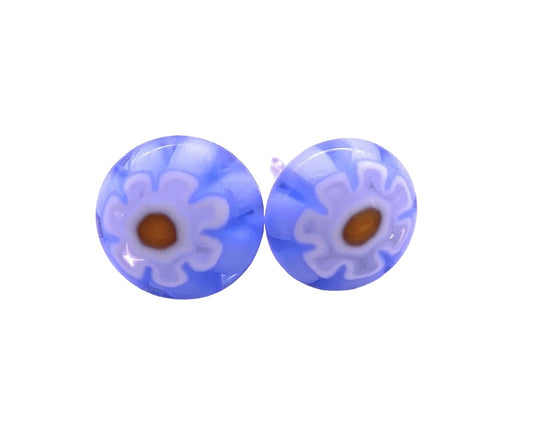 A pair of round earrings featuring delicate white and orange floral designs on a blue Millefiori-style glass, crafted by Calon Glass. Their slightly translucent finish and intricate petal-like patterns make them an excellent choice for creating handmade stud earrings. The dainty earrings measure approximately 0.9 cm and capture the essence of Millefiori artistry.