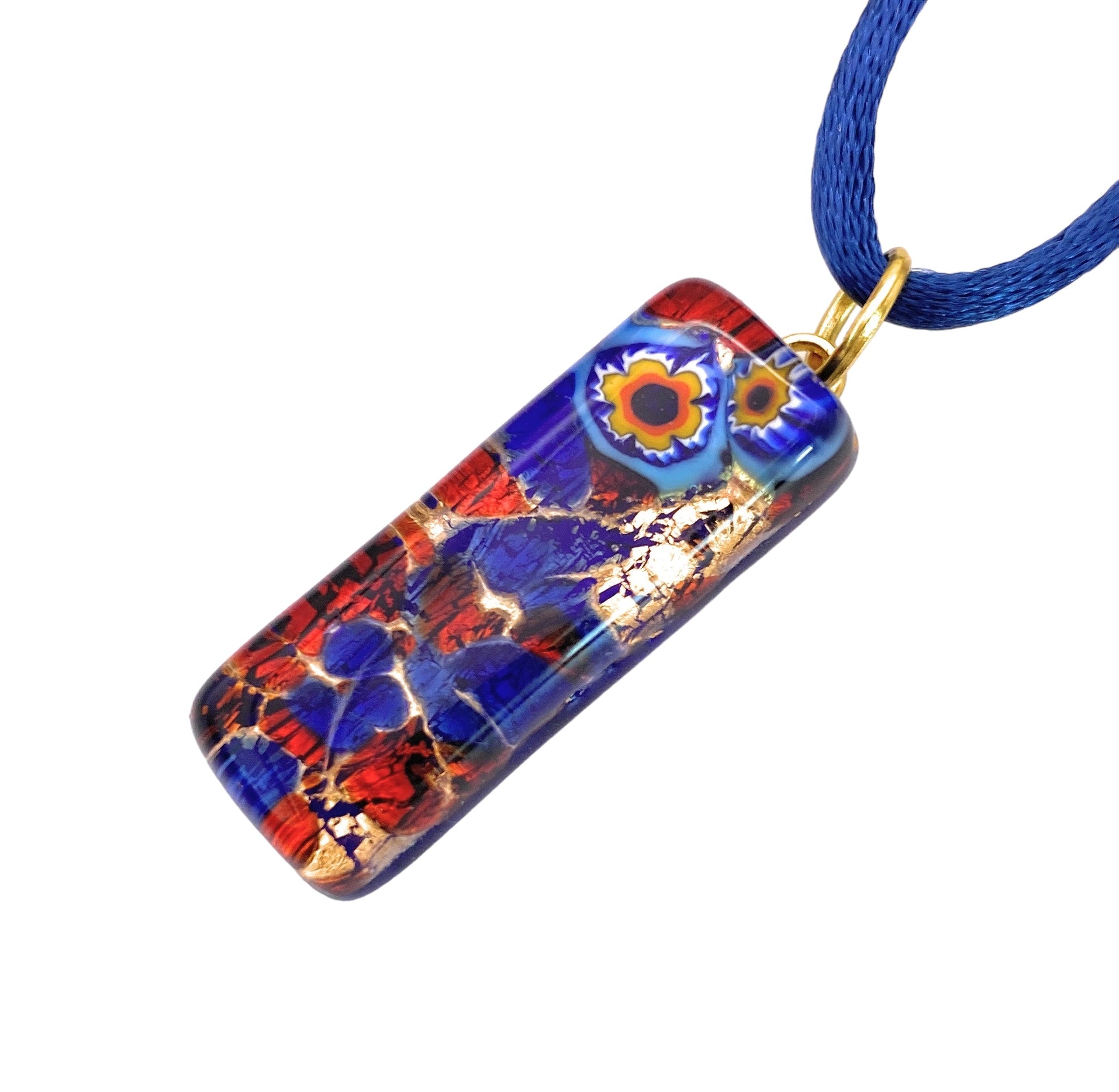 Introducing the Murano Passion's exquisite glass pendant, measuring 3cm x 1cm. This unique piece features vibrant abstract patterns in red, blue, and gold tones with circular designs in orange and blue. The pendant with its distinct Millefiori flowers on gold leaf is elegantly attached to a blue cord necklace and comes with a Certificate of Authenticity.