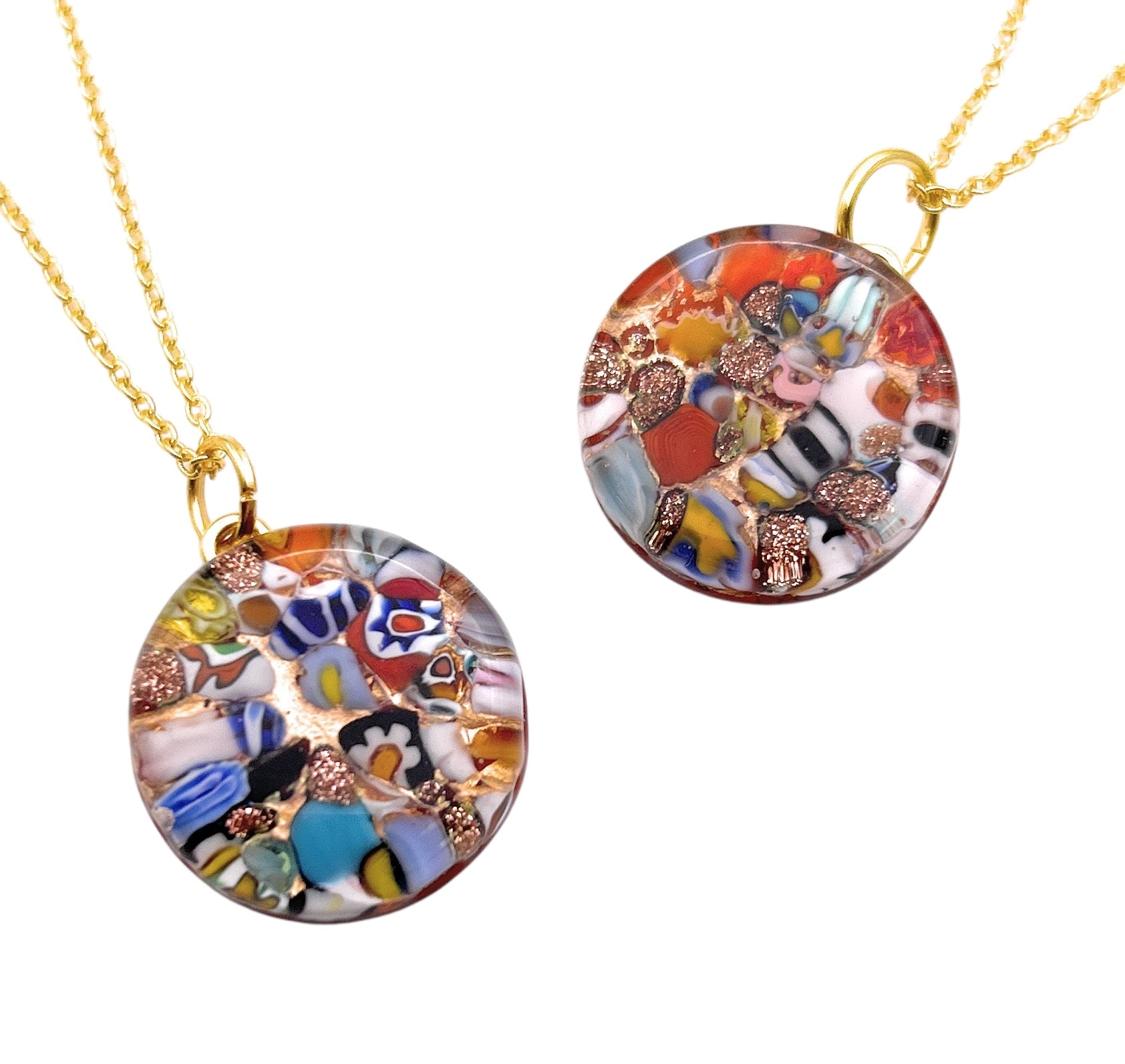 Two 2cm round pendants from Murano Passion hang elegantly on gold chains. Crafted with Millefiori glass, these vibrant multicolored pieces showcase abstract designs that create a striking, artistic appearance. Each pendant includes a Certificate of Authenticity to guarantee its unique craftsmanship.