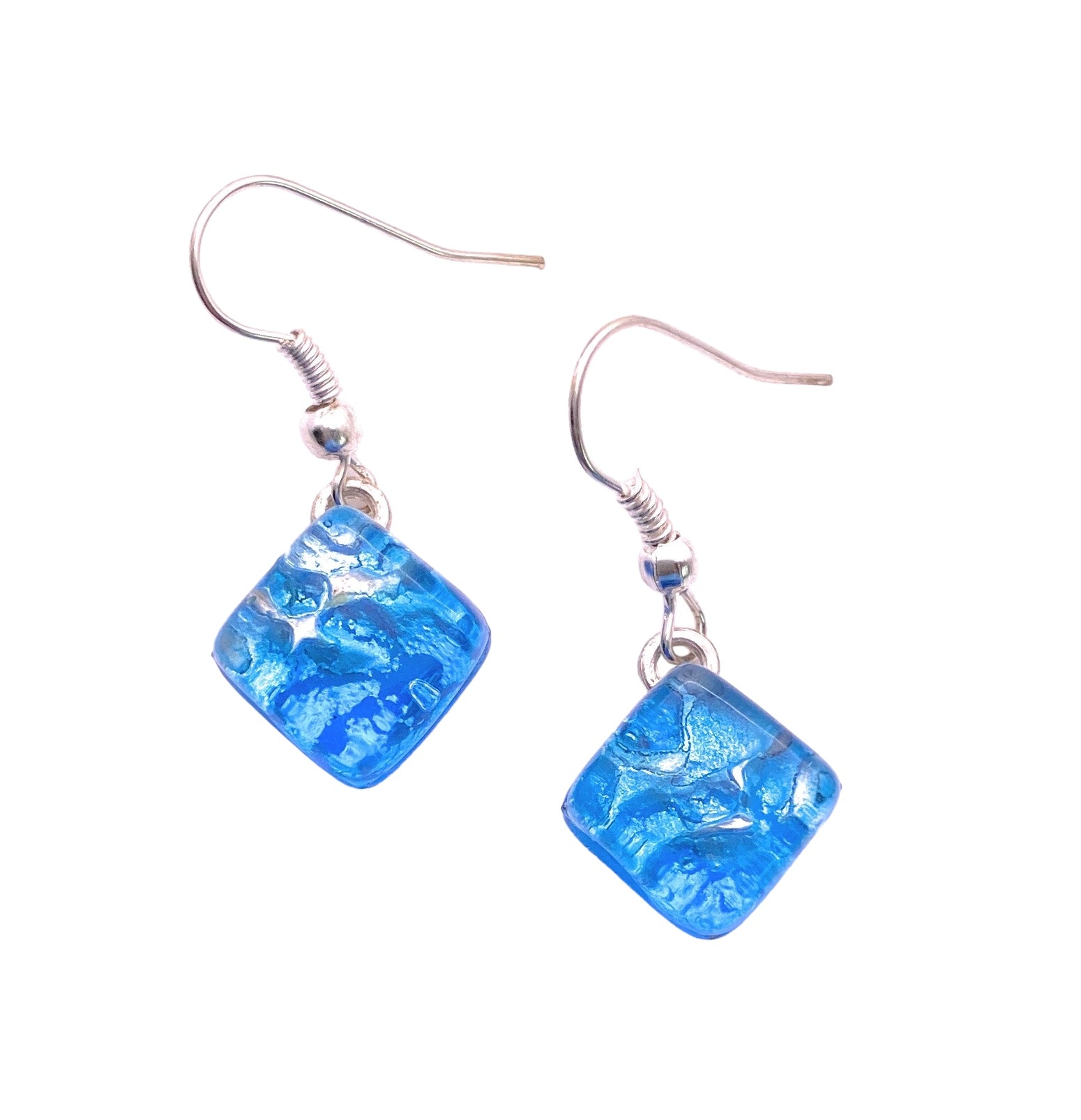 These Murano Passion earrings feature two sky blue, textured square pendants crafted from handmade Murano Glass, dangling elegantly on silver hooks. The pendants showcase a cracked design that beautifully reflects light, capturing the rich Venetian artistic heritage with their shimmering effect.